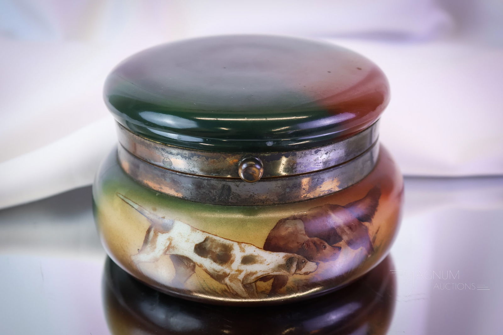 Signed Handel Ware Hunting Dogs Hinged Jar: A signed Handel Ware hunting dog decorated jar. This piece features a hinged top lid. The jar measures 3 1/4" tall and 5 1/4" wide. SHIPPING NOTICE: If you choose not to utilize the LiveAuctioneers Li