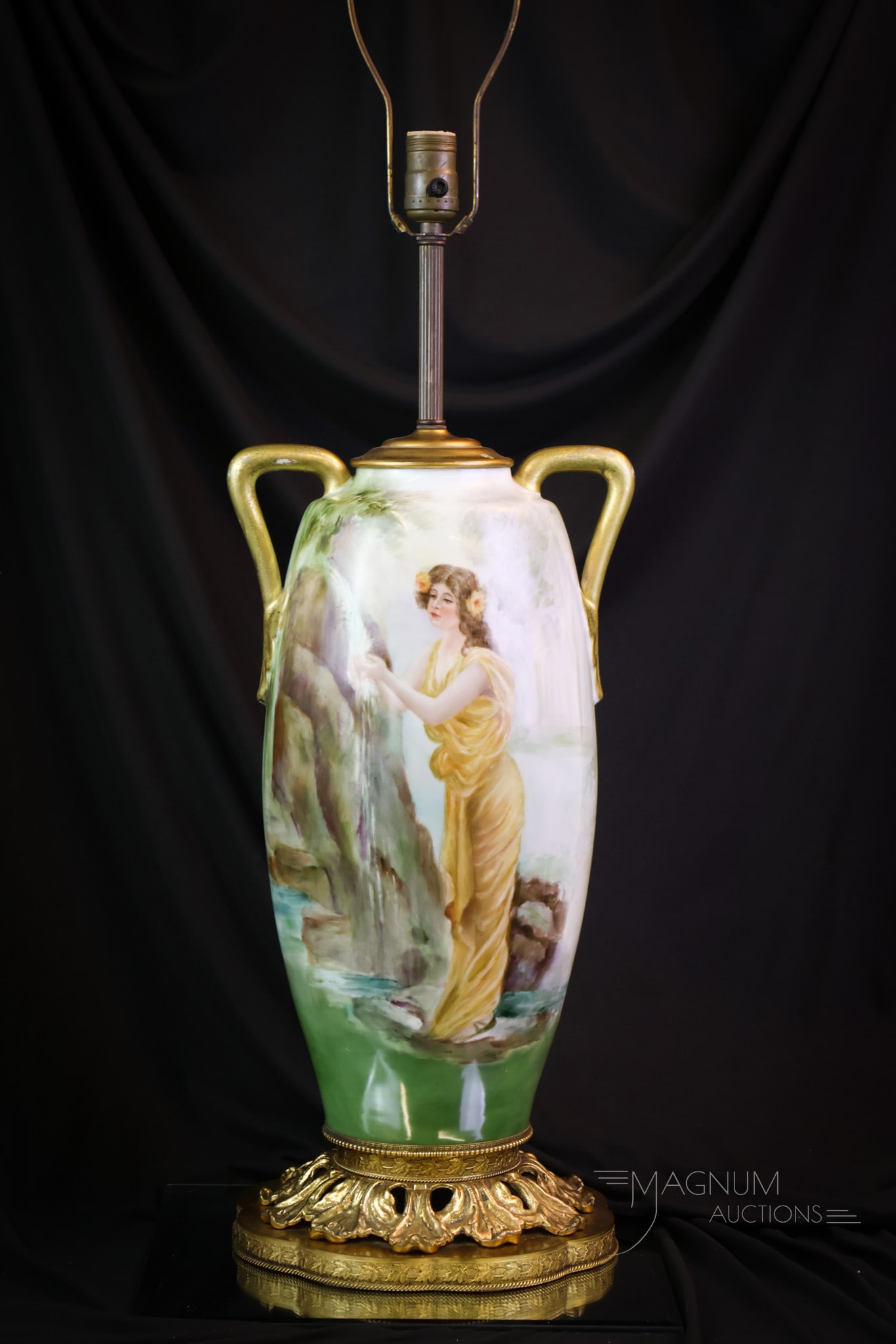 38 1/2" Hand Painted Porcelain "Maiden at the Waterfall" Vase Table Lamp: A wonderful find in a hand-painted Porcelain vase table lamp. This piece features a Maiden at the Waterfall." The vase lamp is fitted with a great gilt base complemented by the gold handles. The porce