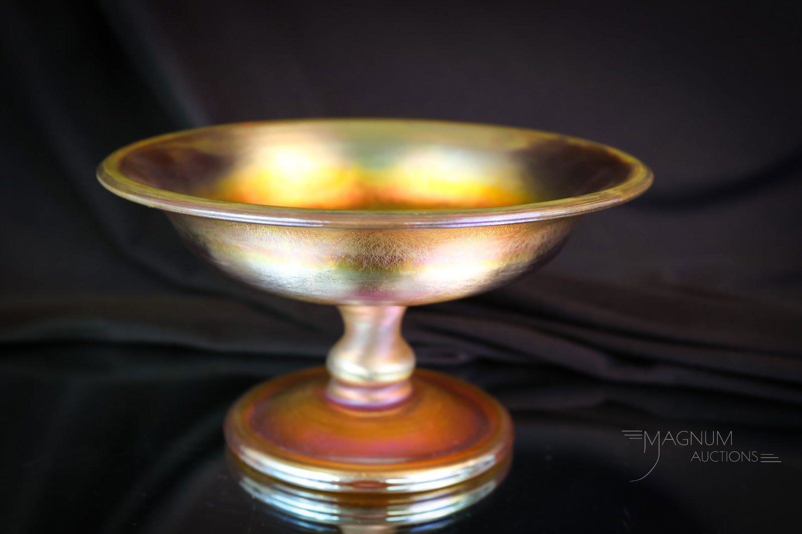 L.C. T. Tiffany Favrile Art Glass Gold Iridescent Compote: A charming marked, "L.C.T. Favrile" Tiffany gold iridescent glass compote. This beautiful little piece measures 3 1/4" tall and 6" in diameter. Electrifying color! SHIPPING NOTICE: If you choose not t