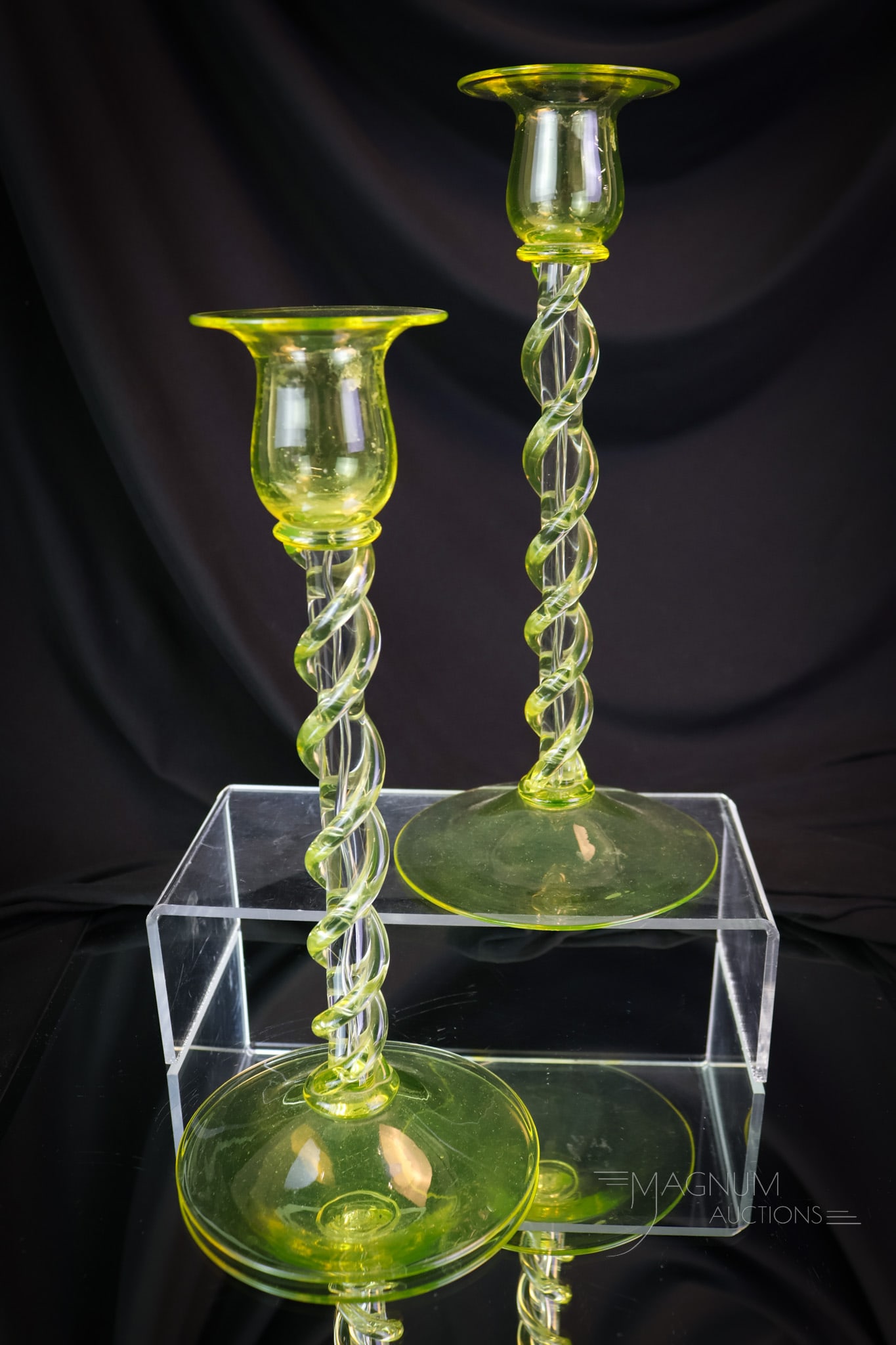 Pair Steuben Vaseline Topaz Uranium Twist Art Glass Candlesticks: A fine and seldom-found pair of Steuben candlesticks. The pair measures 10" tall and 4 1/2" wide. Each is in crystal with a double vaseline uranium-rich Topaz twist around each stem. These light up un
