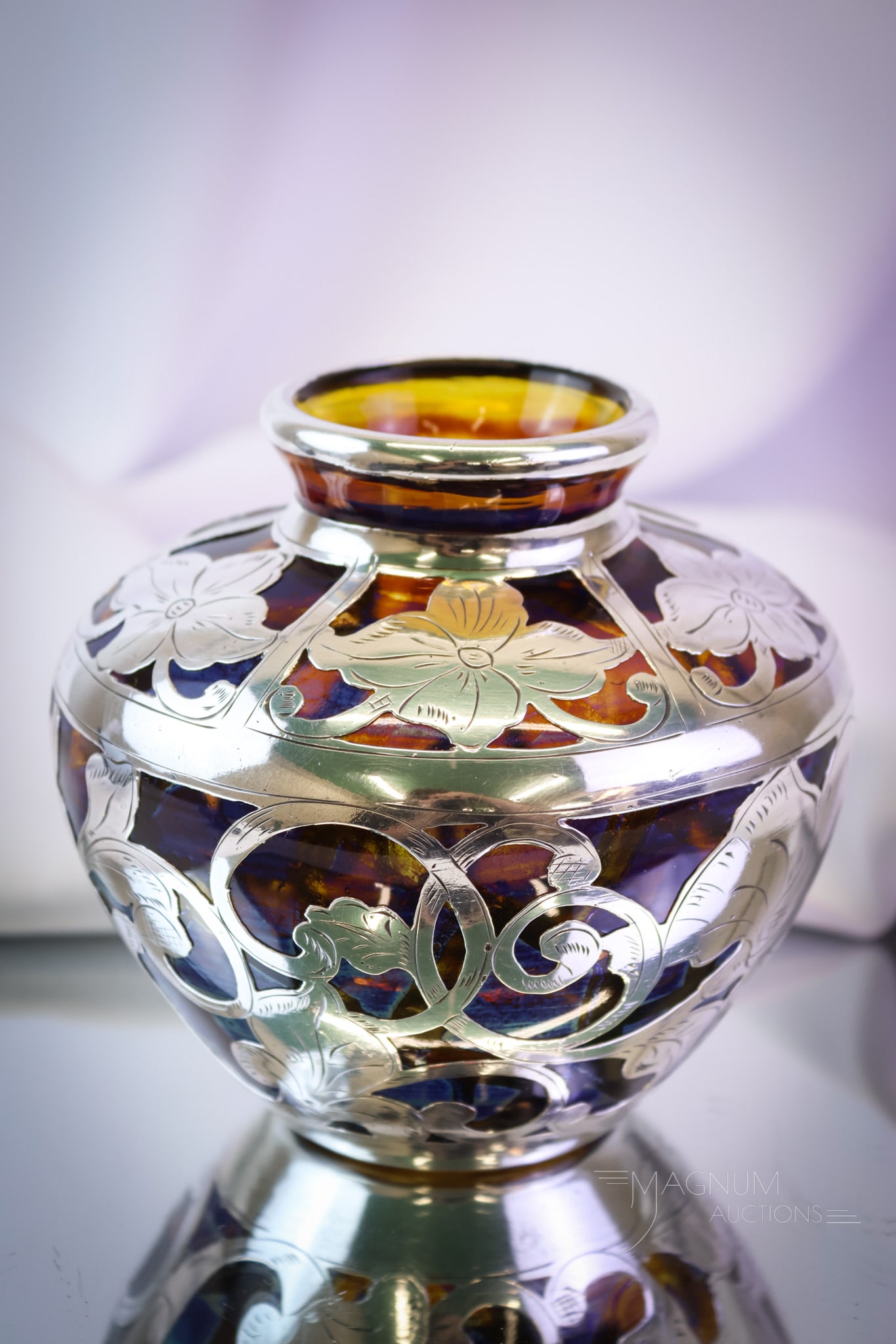 Art Nouveau Sterling Overlay 999/1000 Fine Art Glass Vase: A wonderful Sterling floral decorated overlay art glass vase. This piece is marked, "999/1000 Fine." It is in an Art Nouveau style. The glass is a raisin color with abbreciated segments of iridescence