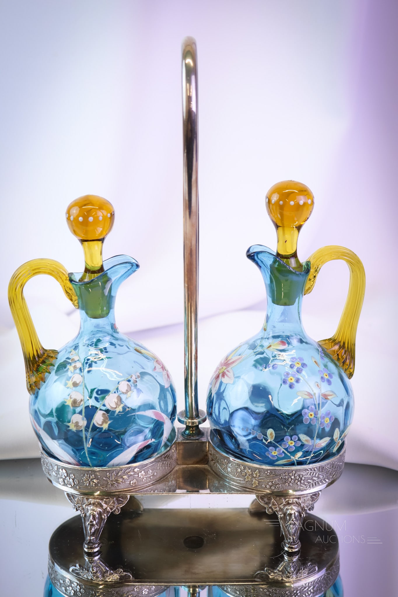 Meriden Silverplate Enameled Glass Victorian Cruet Set: A fine offering of a pair of Victorian Azure blue enameled art glass cruets set in a signed Meriden silverplate holder. This offering is amazing. When do you see them? The set measures 10 1/2" tall. S