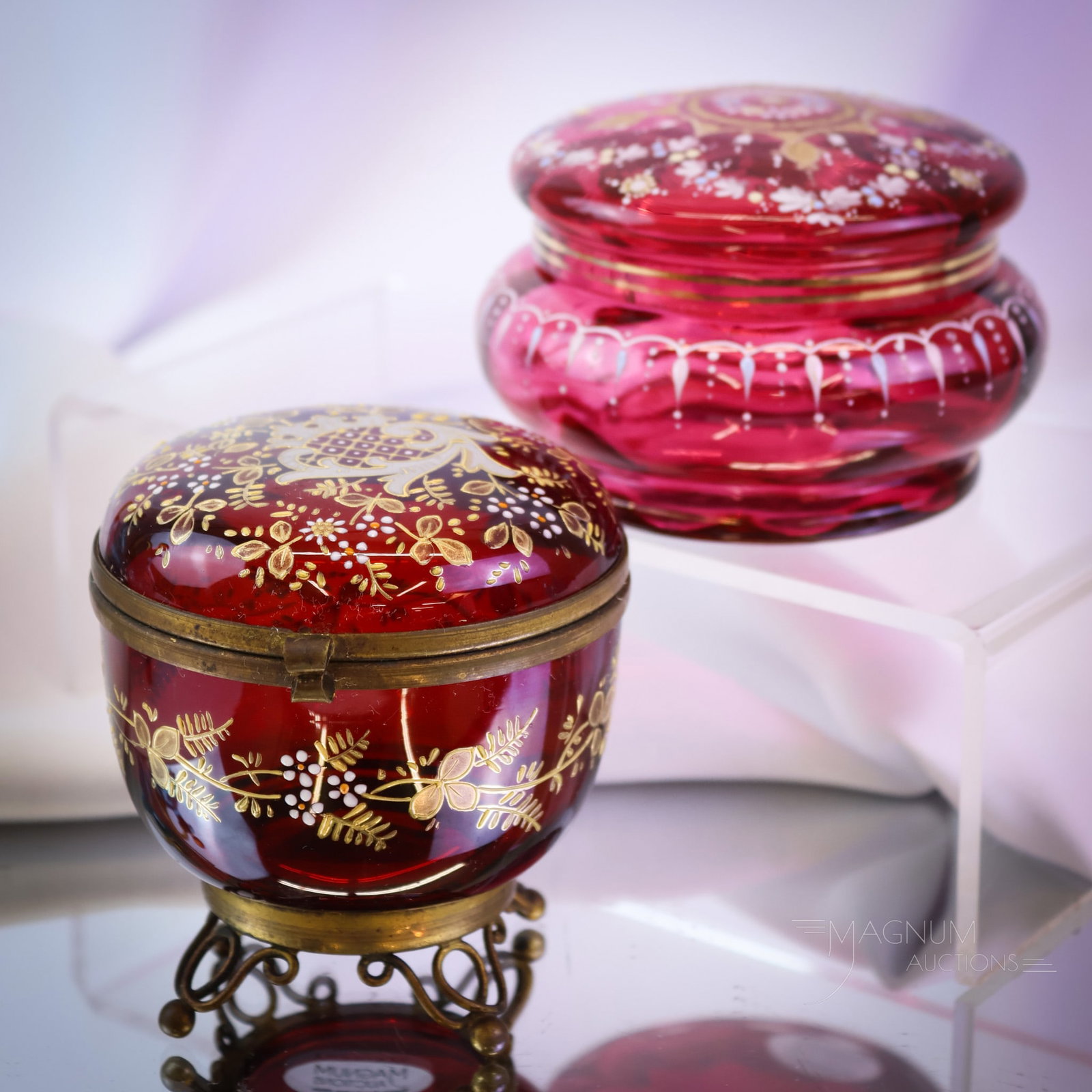 2 pc Lot Victorian Cranberry Gilt Enameled Dresser Boxes: Two fine examples of Victorian cranberry dresser boxes. Each is enamel decorated with wonderful gold and more. One box has a hinged lid. The other has a lift-off lid. The tallest measures 3 1/2". SHIP