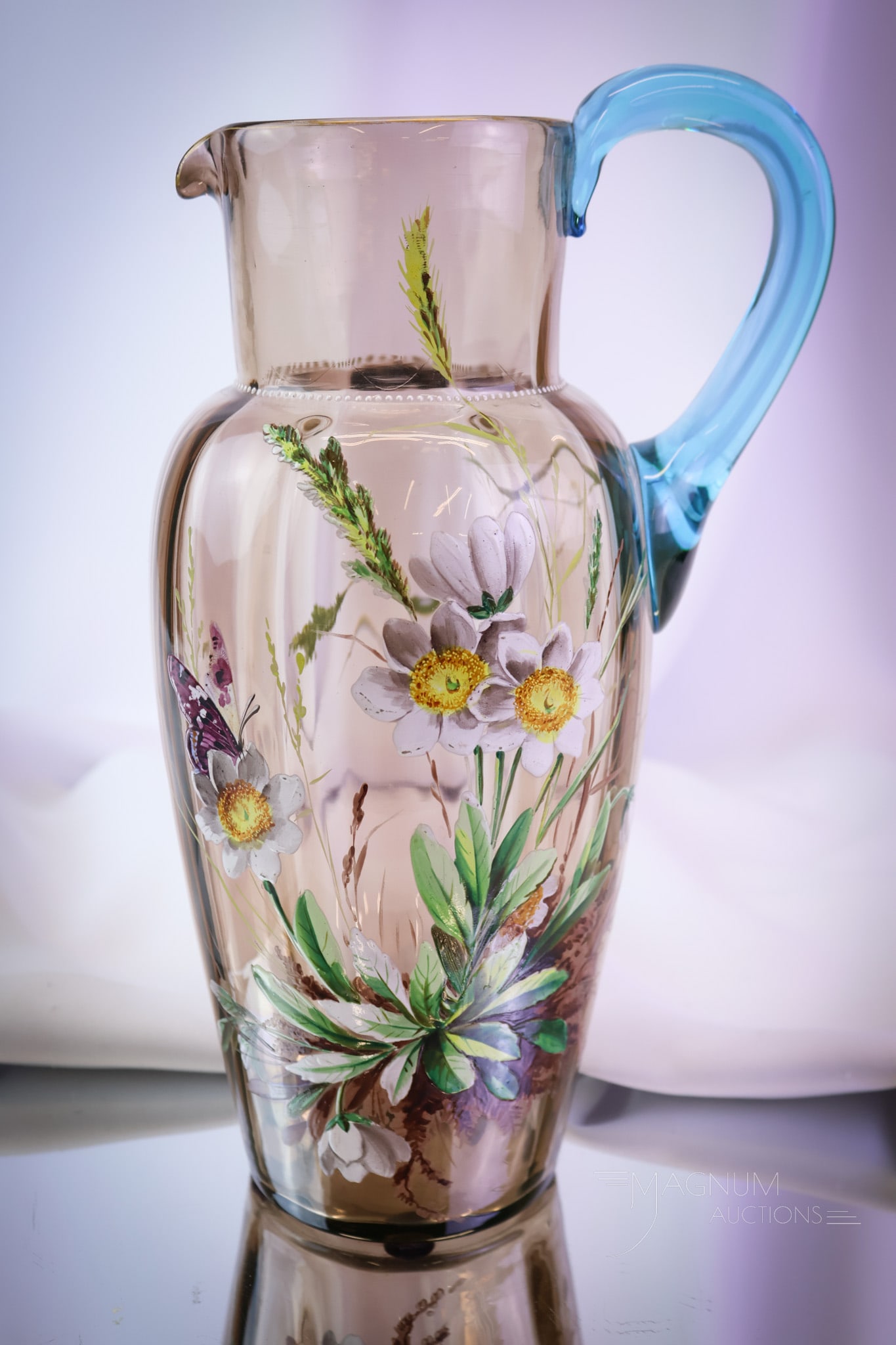Victorian 11 1/2" Enameled Glass Bohemian Water Pitcher: A beautifully enameled Victorian art glss pitcher. The pitcher is in smoky amber with a brilliant blue handle. The pitcher measures 11 1/2" tall. SHIPPING NOTICE: If you choose not to utilize the Live