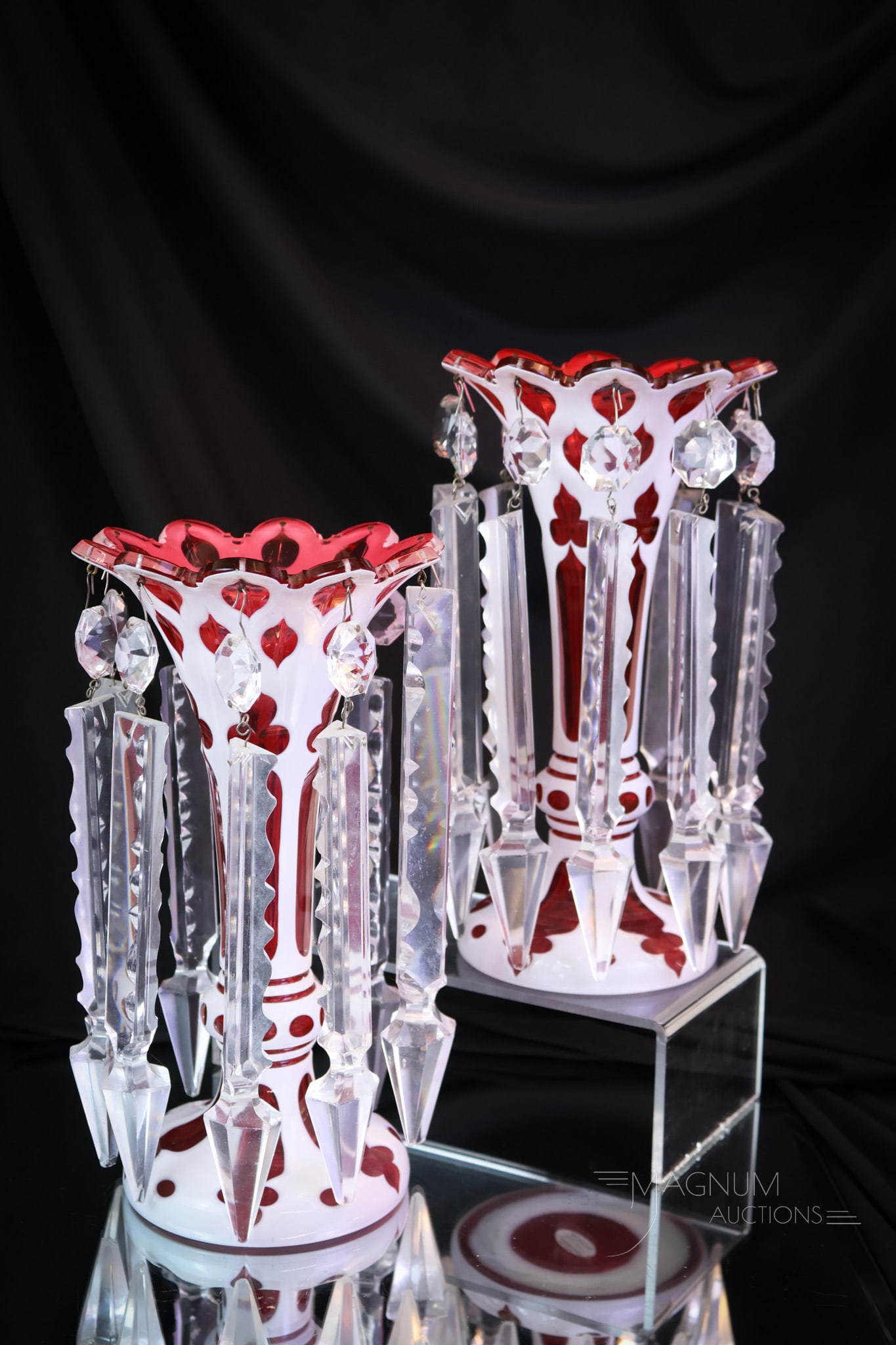 Pair Cranberry Cut Overlay Victorian Art Glass Lusters: A striking pair of Victorian cranberry cut overlay art glass lusters. Each of these measures 9 1/2" tall. Full-length prisms accent this pair of fineries for the mantle. Each measures 9 1/2" tall and