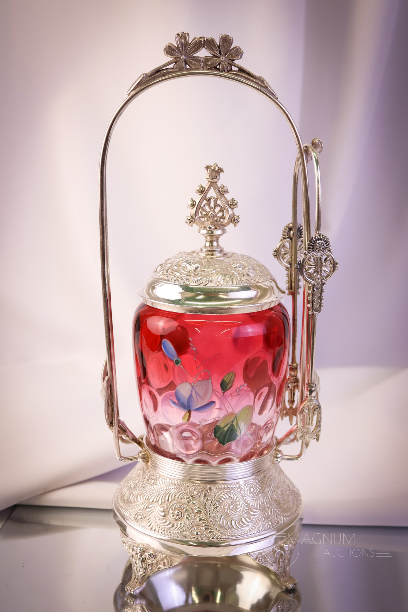 St. Louis Silverplate Co. Victorian Cranberry Rubina Pickle Castor: A wonderful example of Victorian silverplate and glass. This is a signed St. Louis silverplate frame with a cranberry rubina enameled glass jar. The castor frame has adornments of foliage. The jar is