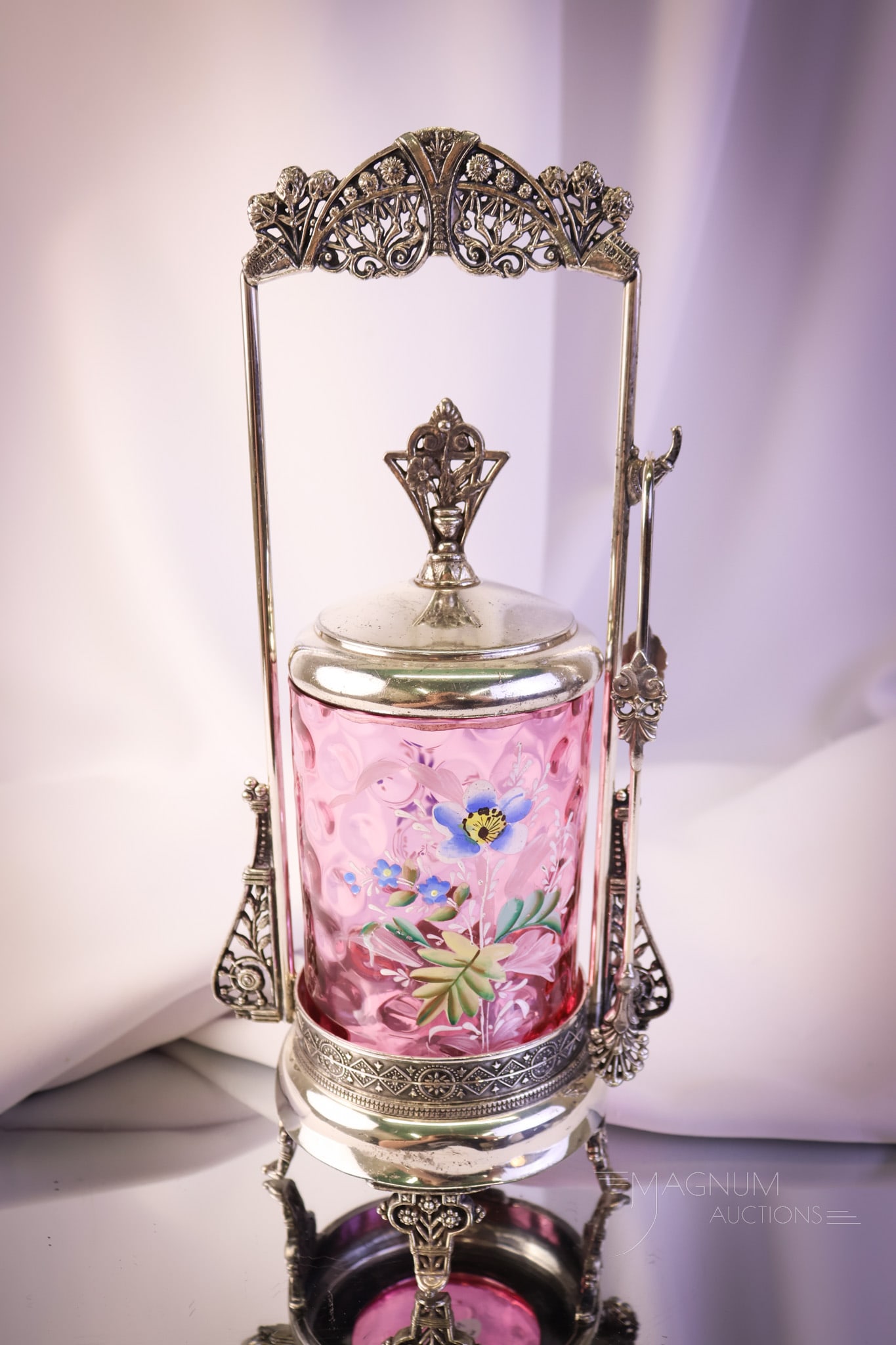 Victorian Silverplate Cranberry Enameled Glass Pickle Castor: A wonderful find in a truly beautiful Victorian pickle castor. This super piece has a cranberry inverted thumbprint enameled pickle jar set in a marked but illegible silverplate ornate frame. This cas