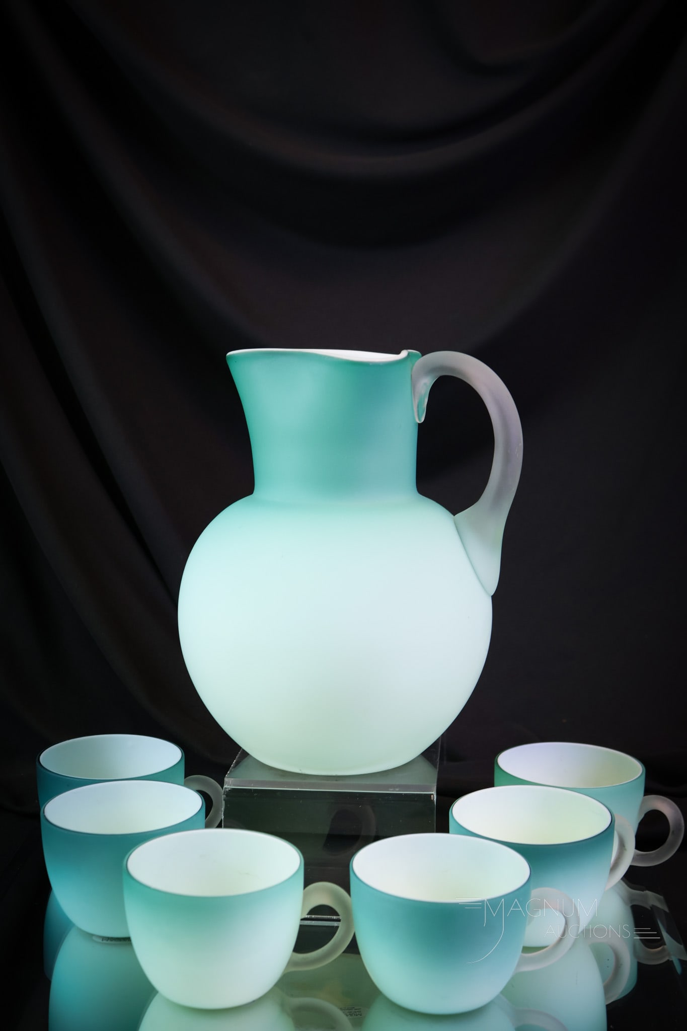 Victorian Phoenix Uranium-Blue Art Glass 6 pc Water Set: A uranium-rich Victorian blue cased glass six-piece water set. This set consists of five cups and a pitcher. The set glows brightly under black light. The tallest of the offerings measures 8". SHIPPIN