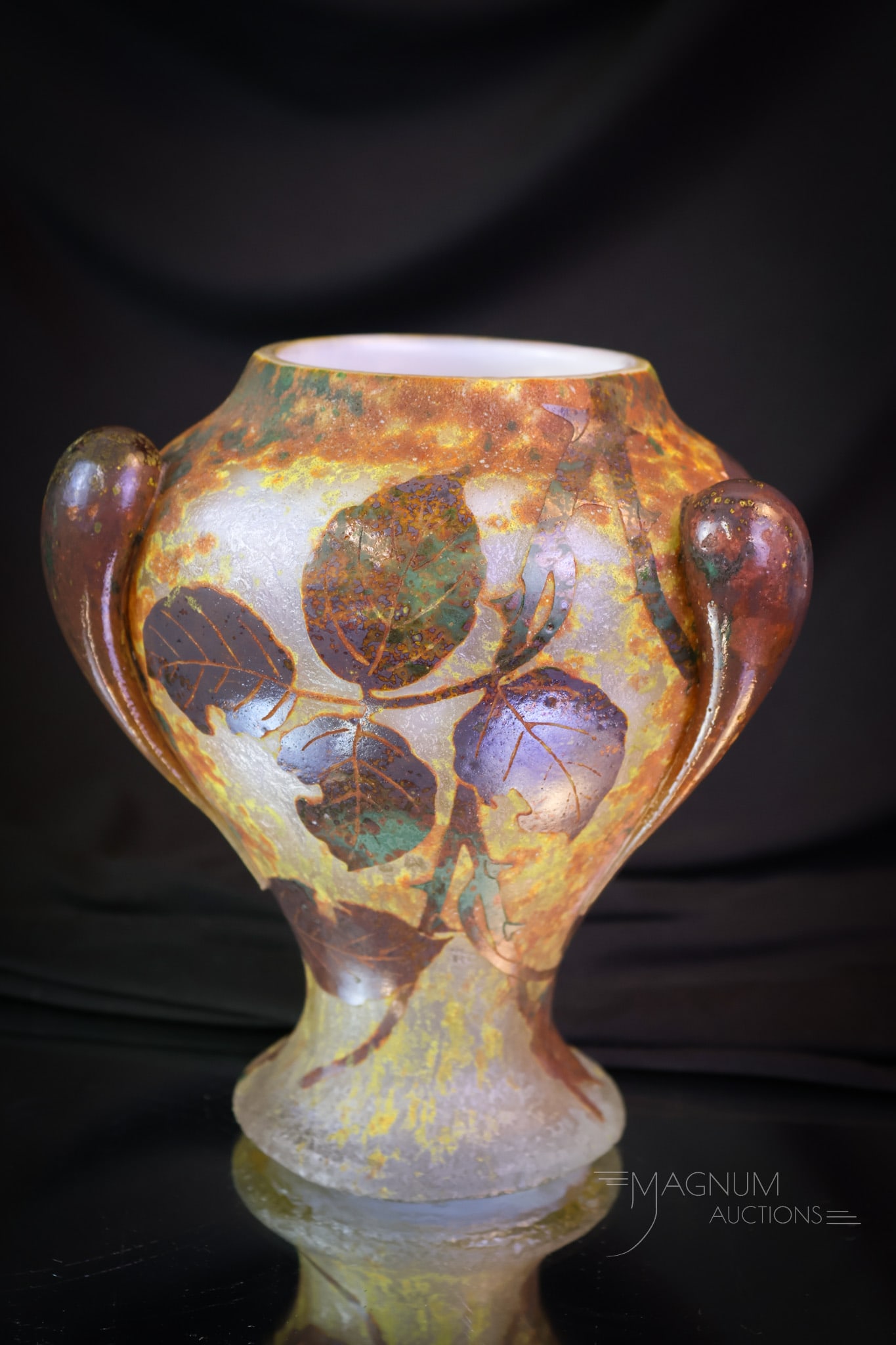 Signed Daum Nancy French Cameo Art Glass Vase: A fine offering in this piece of signed Daum Nancy French cameo art glass. This vase has applied tadpole decoration and mottled coloring with leaves. The vase measures 7" tall. SHIPPING NOTICE: If you