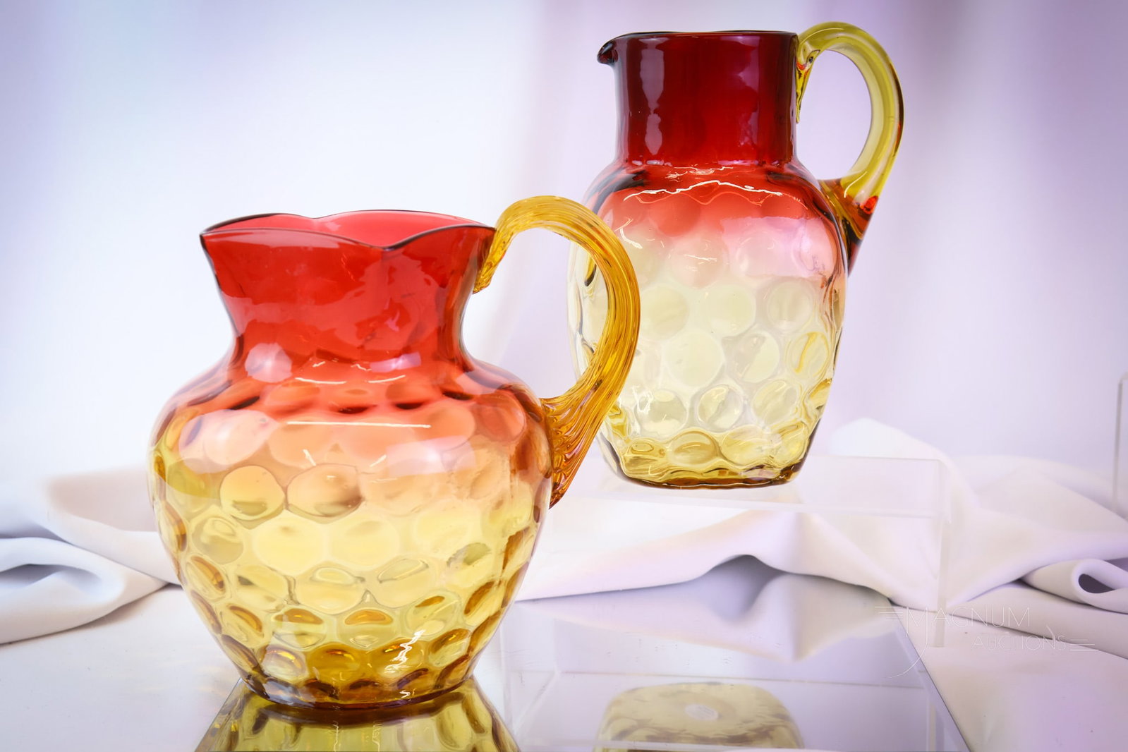 2 pc Lot Victorian Amberina Glass Water Pitchers Hobbs & Phoenix: two unique finds in Victorian amberina glass water pitchers. One is a square-shaped with an Inverted Thumbprint pattern. The other is a traditional Hobbs shape in the same pattern. The tallest measure