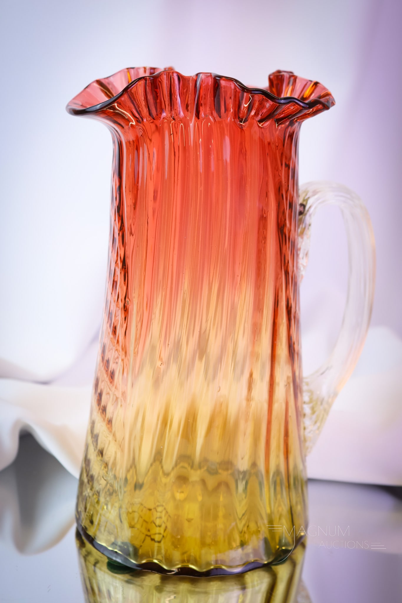 Victorian Amberina Waffle Swirl Glass Tankard Water Pitcher: An unusual find in Victorian amberina glass. This is a tankard-style pitcher with a Waffle-Swirl pattern. The pitcher has a ruffled top rim and a clear, applied glass handle. The piece measures 10 1/2