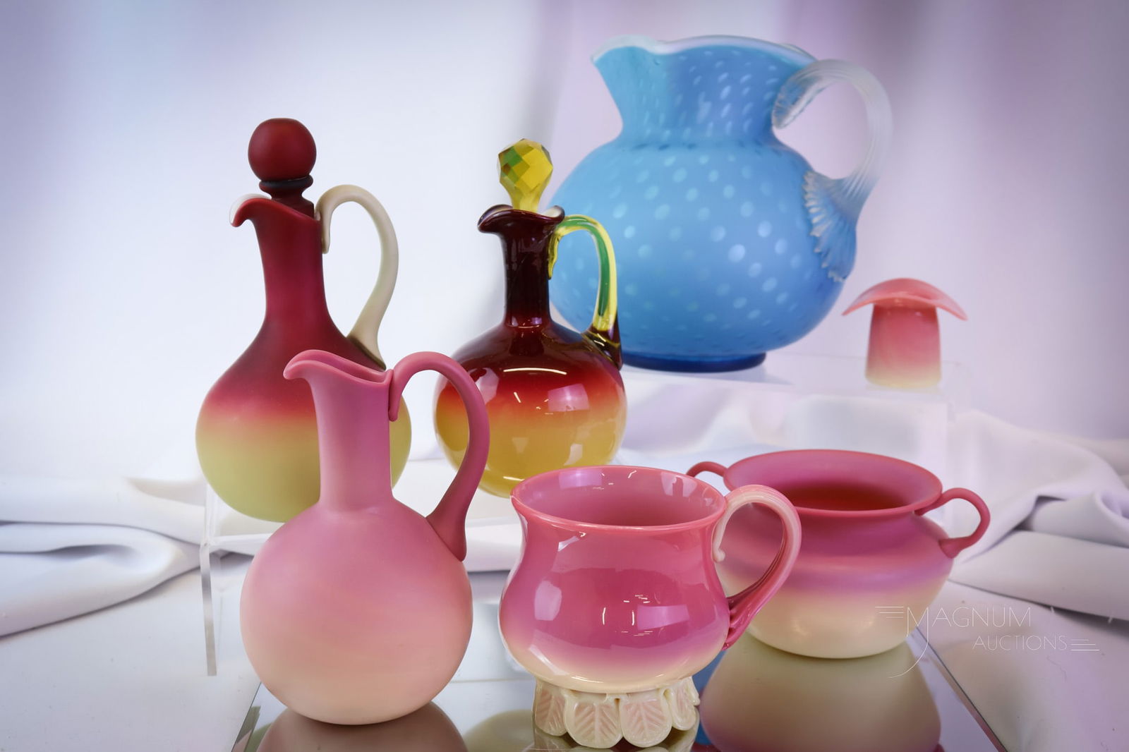 7 pc Lot Victorian Gunderson Pairpoint Italian Uranium Art Glass: Seven distinct finds in art glass in this generous offering. This lot has a blue mother-of-pearl Victorian glass water pitcher. An assortment of Gunderson Pairpoint burmese glass. There are two cruets