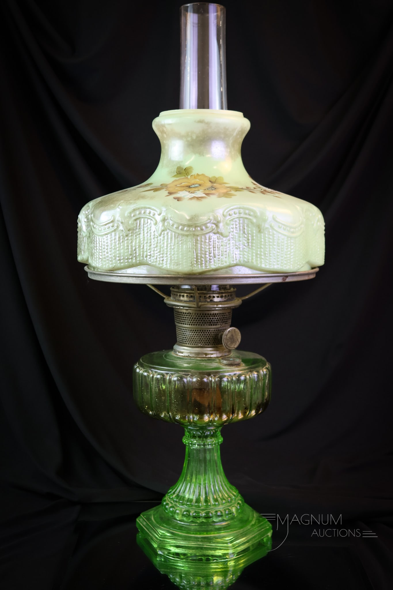 Aladdin Corinthian Uranium Green Oil Lamp: A beautiful and estate-fresh Aladdin oil lamp in the Corinthian pattern. This lamp was made in uranium-rich green glass. It is found with the original burner. It comes complete with a painted shade an