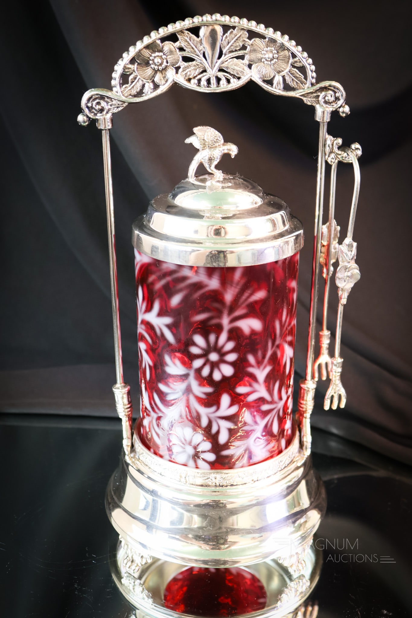 Fenton Cranberry Opalescent Daisy & Fern Pickle Castor: A showy piece for the curio shelf. This is a cranberry opalescent Daisy & Fern pattern pickle castor by Fenton Art Glass. It includes an unmarked silverplate frame. The lid features a brid finial. The