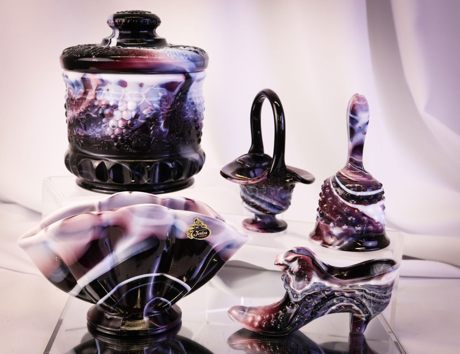 5 pc Lot Fenton Levay Purple Slag Art Glass: Five distinct finds in Fenton for Levay purple slag art glass.. This lot includes a tobacco jar, a bell, a slipper, a basket, and finally, a rare fan vase. The tallest measures 7 1/2" tall.