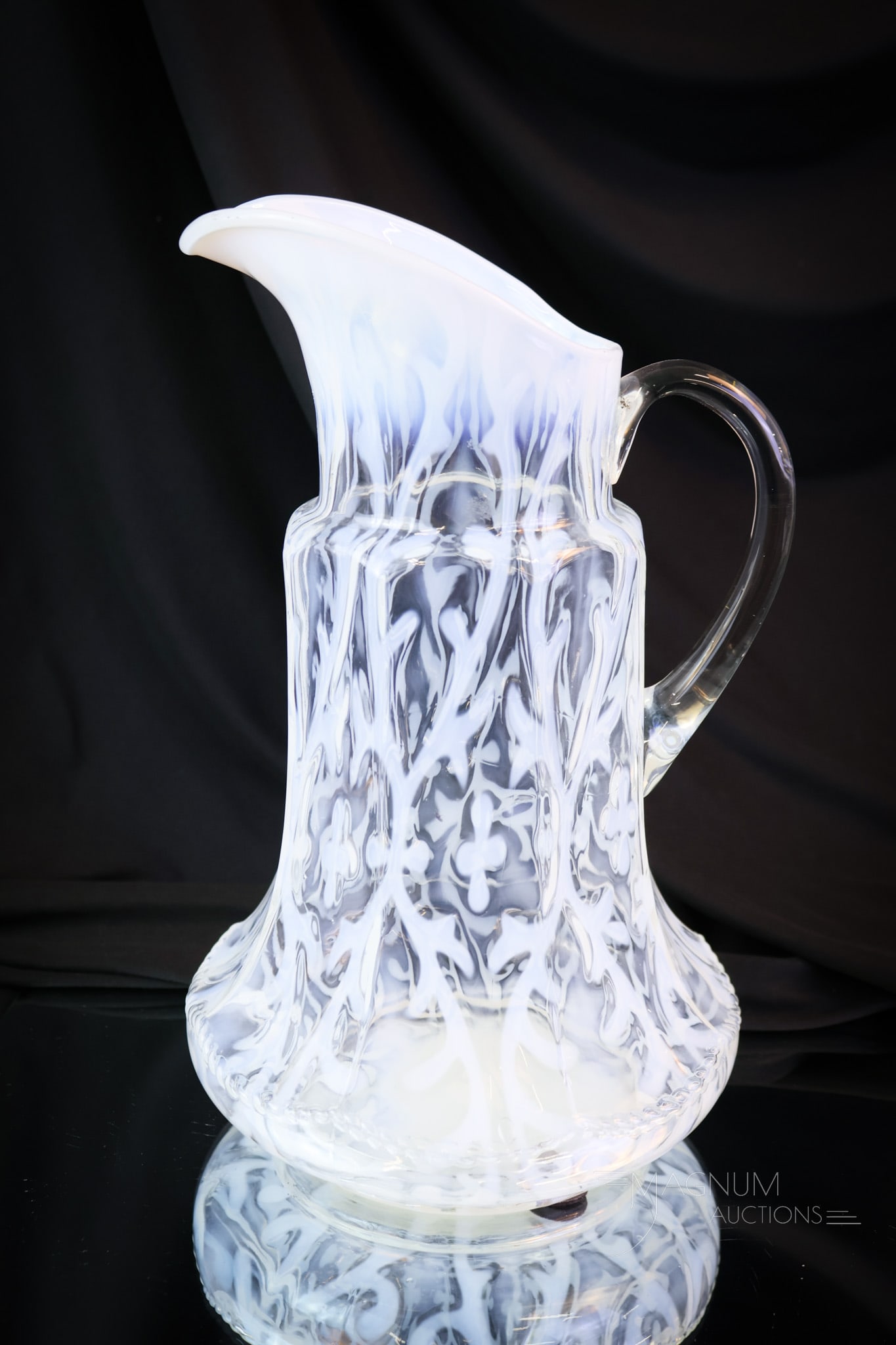 Northwood Spanish Lace Victorian Opalescent Glass Tankard Pitcher: A fine example of a Northwood Spanish Lace opalescent tankard pitcher. This one is in the nine-panel mold. The pitcher measures 11 1/4" tall and 6 1/2" wide.