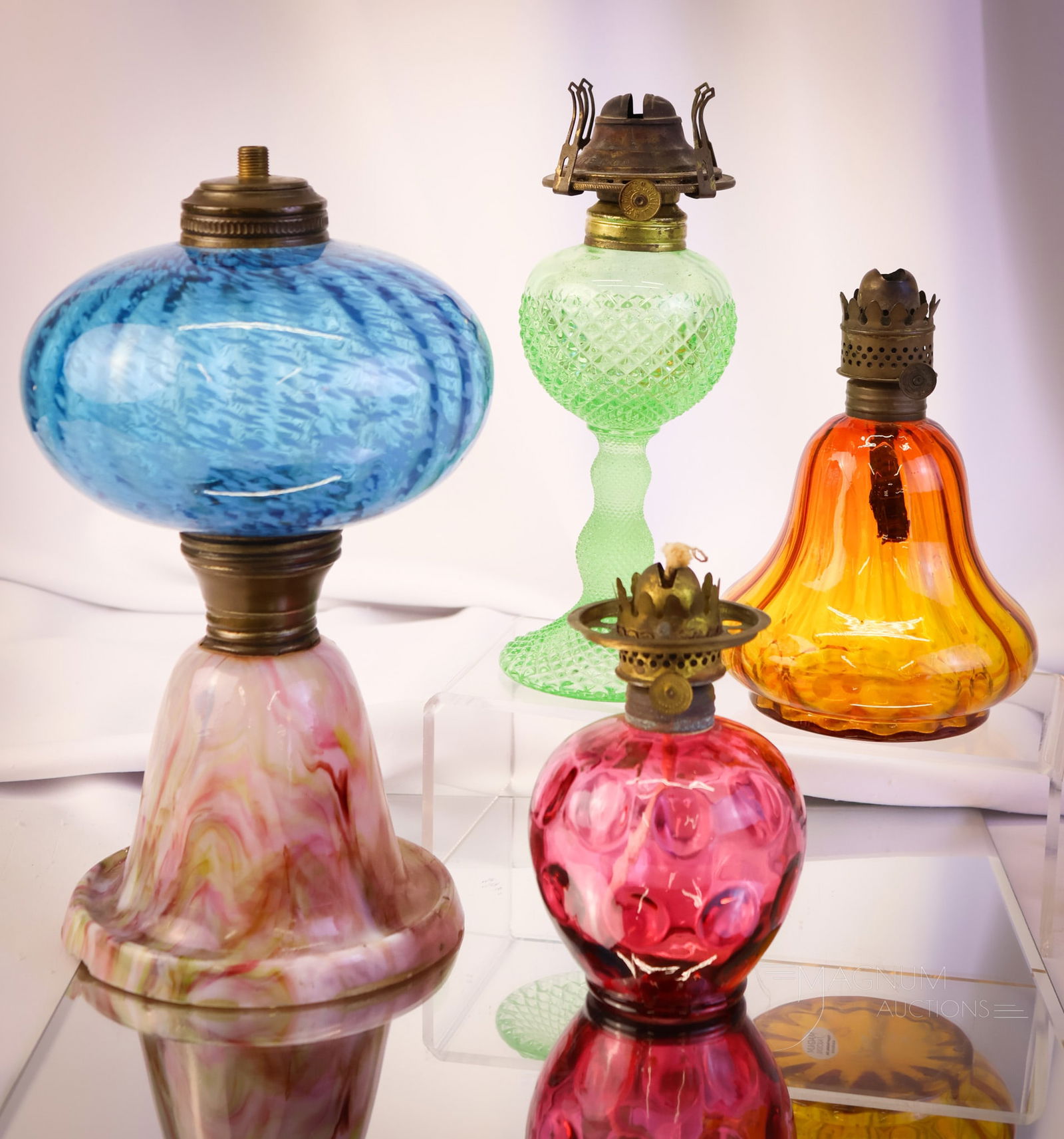 4 pc Lot Victorian & More Glass Oil Lamp Bases: Four finds in collectible oil lamp bases for your bidding pleasure. There are three miniature bases. Those are represented by an amberina rib-optic example. A cranberry Fenton Inverted Thumbprint exam