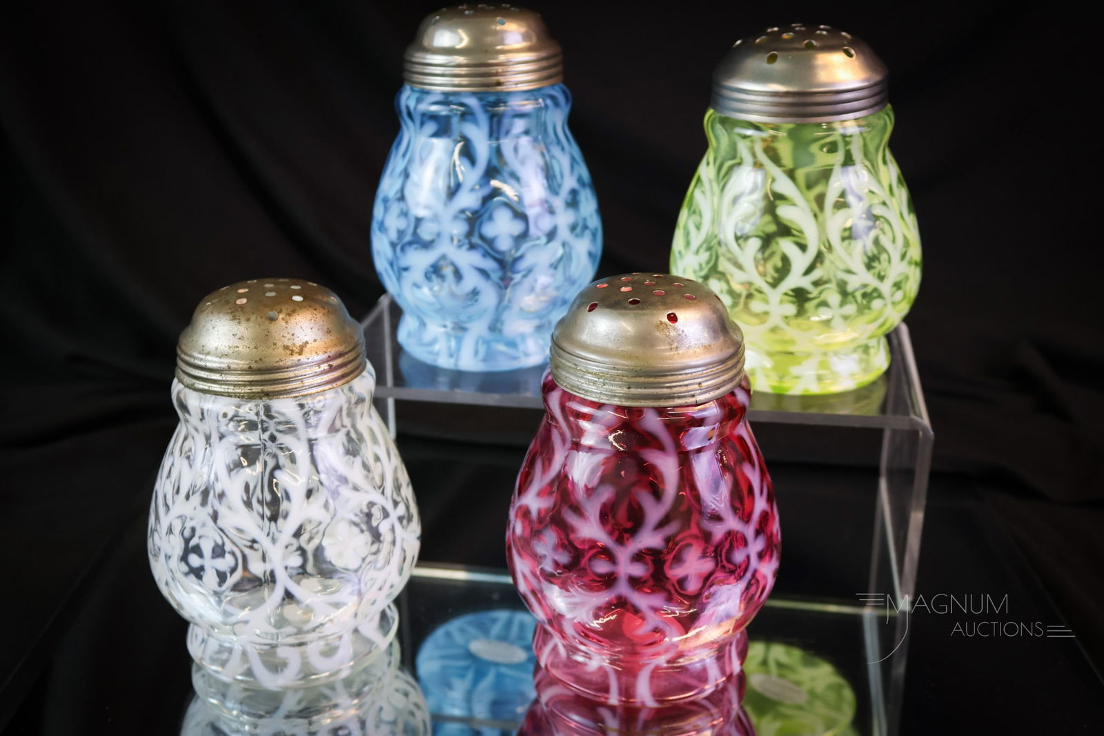 4 pc Lot Northwood Spanish Lace Victorian Opalescent Glass Sugar Shakers: A variety of colors are present in this lot of Victorian Northwood Spanish Lace pattern. One in cranberry, one in vaseline, one in white opal, and the last in blue. The tallest measures 4 1/4".
