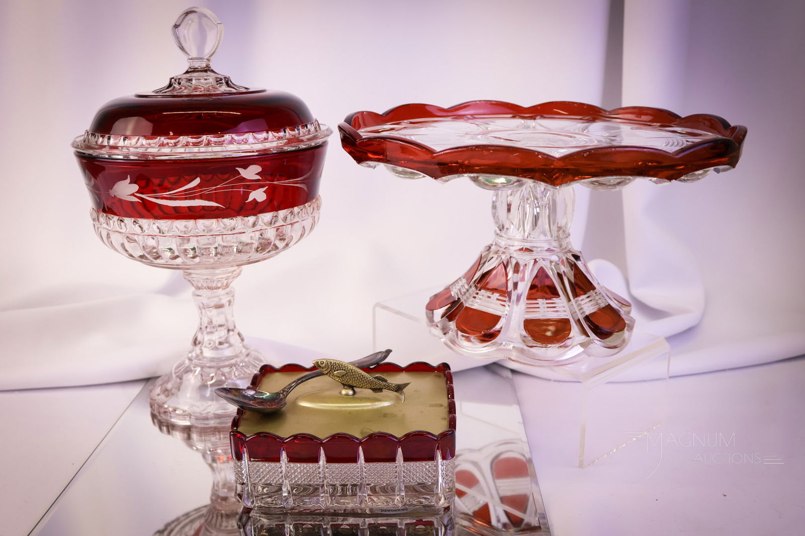 3 pc Lot Victorian Ruby Stained Glass Duncan U.S. Glass: Three vibrant finds in rich ruby-stained Victorian glass. This lot offers a tall covered compote with etching. A Duncan barred Ovals pedestal cake stand. Lastly, there is a banded Portland Sardine box