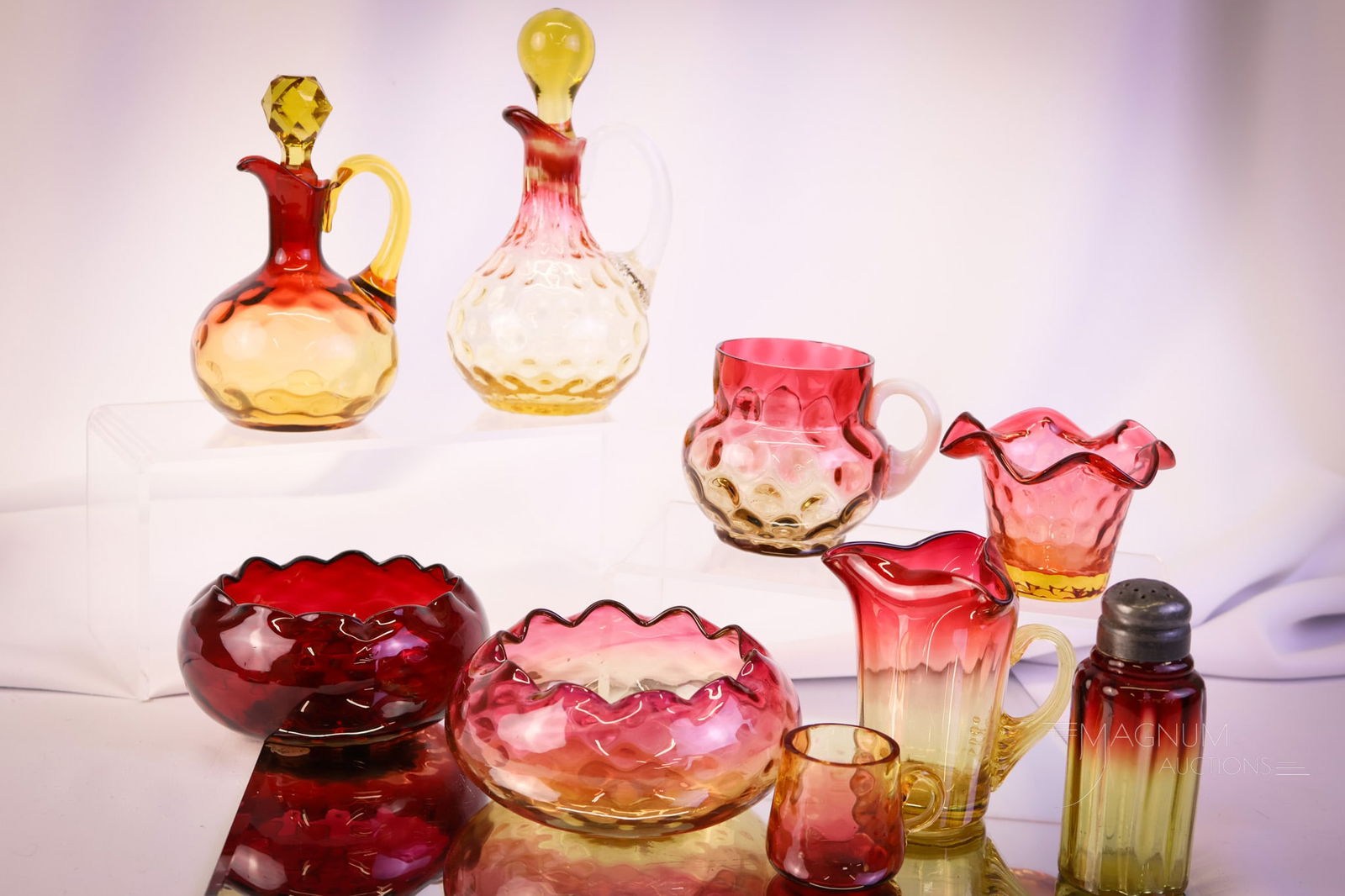 9 pc Lot "Guilty Pleasures" in Victorian Amberina Glass: Nine finds in Victorian amberina art glass. This lot includes two cruets, one shaker, two finger bowls, one toothpick holder, one cream pitcher, a punch cup, and lastly, a mini cup. The tallest measur