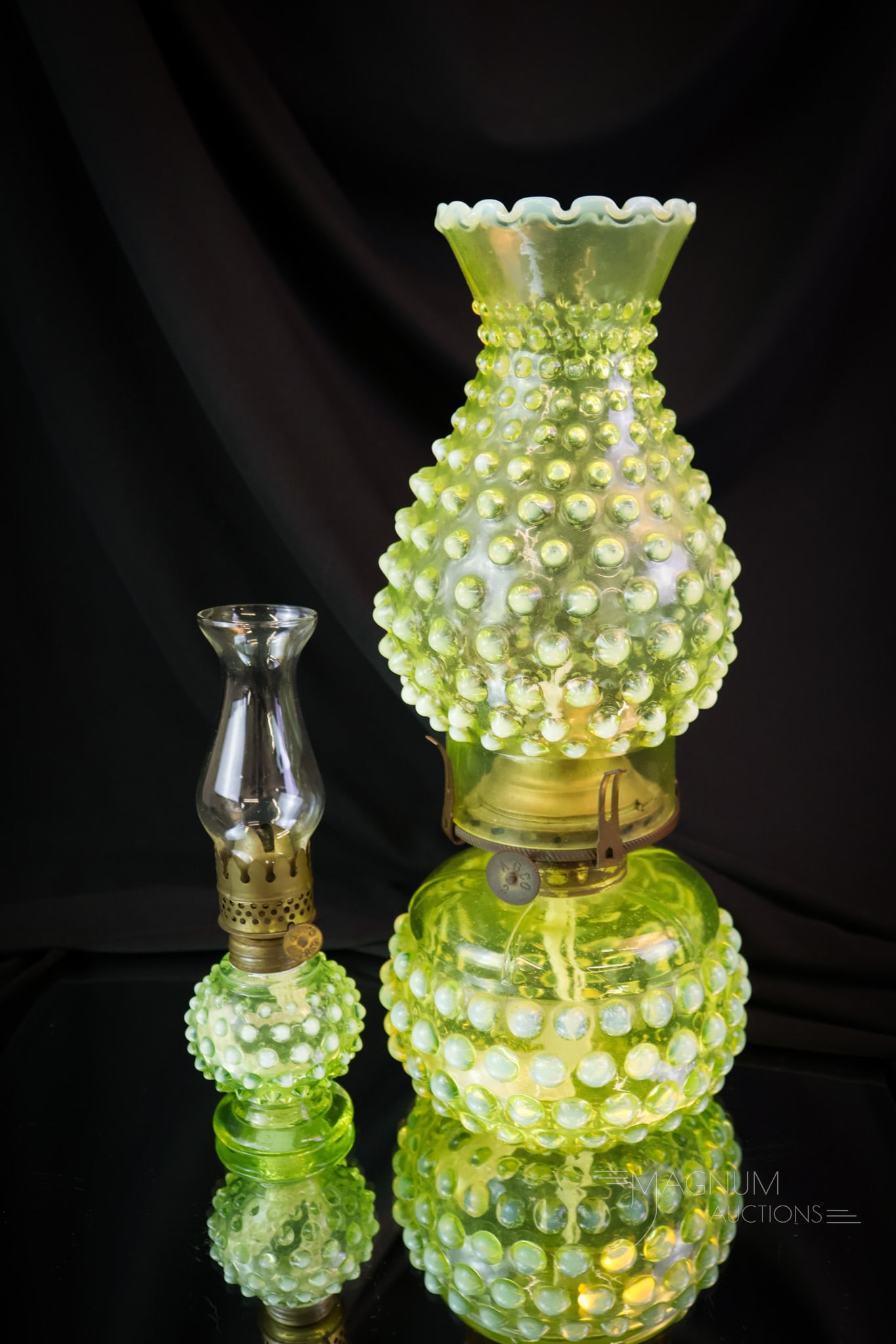 2 pc Lot Uranium Vaseline Opalescent Hobnail Oil Lamps: Two lovely and glowing uranium-rich vaseline opalescent Hobnail pattern oil lamps by Imperial Glass. This lot features a mini-lamp with a clear chimney, and a full-size lamp with a matching chimney. T