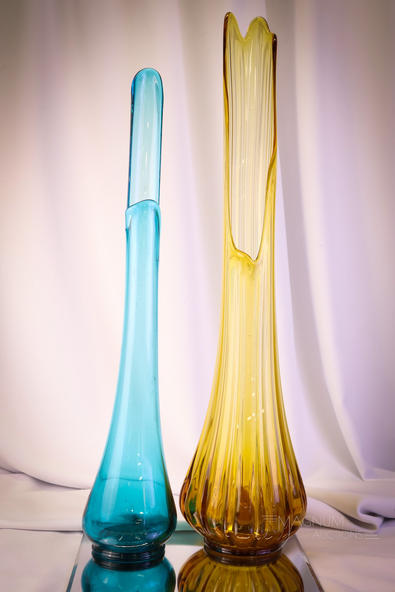 2 pc Lot MCM LE Smith Art Glass Swung Vases: Two divine pieces of mid-century modern L.E. Smith art glass in the form of swung vases. This lot will drive the swingers insane! The first is a teal smoothie. The second is an amber ribbed for pleasu