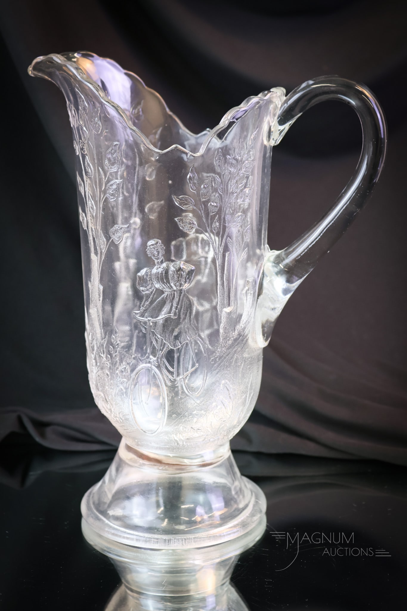 Greentown Victorian Glass Bicycle Girl Tankard Water Pitcher: A scarce find in Victorian Greetown glass. This is a Bicycle Girl pattern pitcher. This graceful tankard is a prize to behold in any collection. The pitcher measures 11" tall. Provenance: This item i