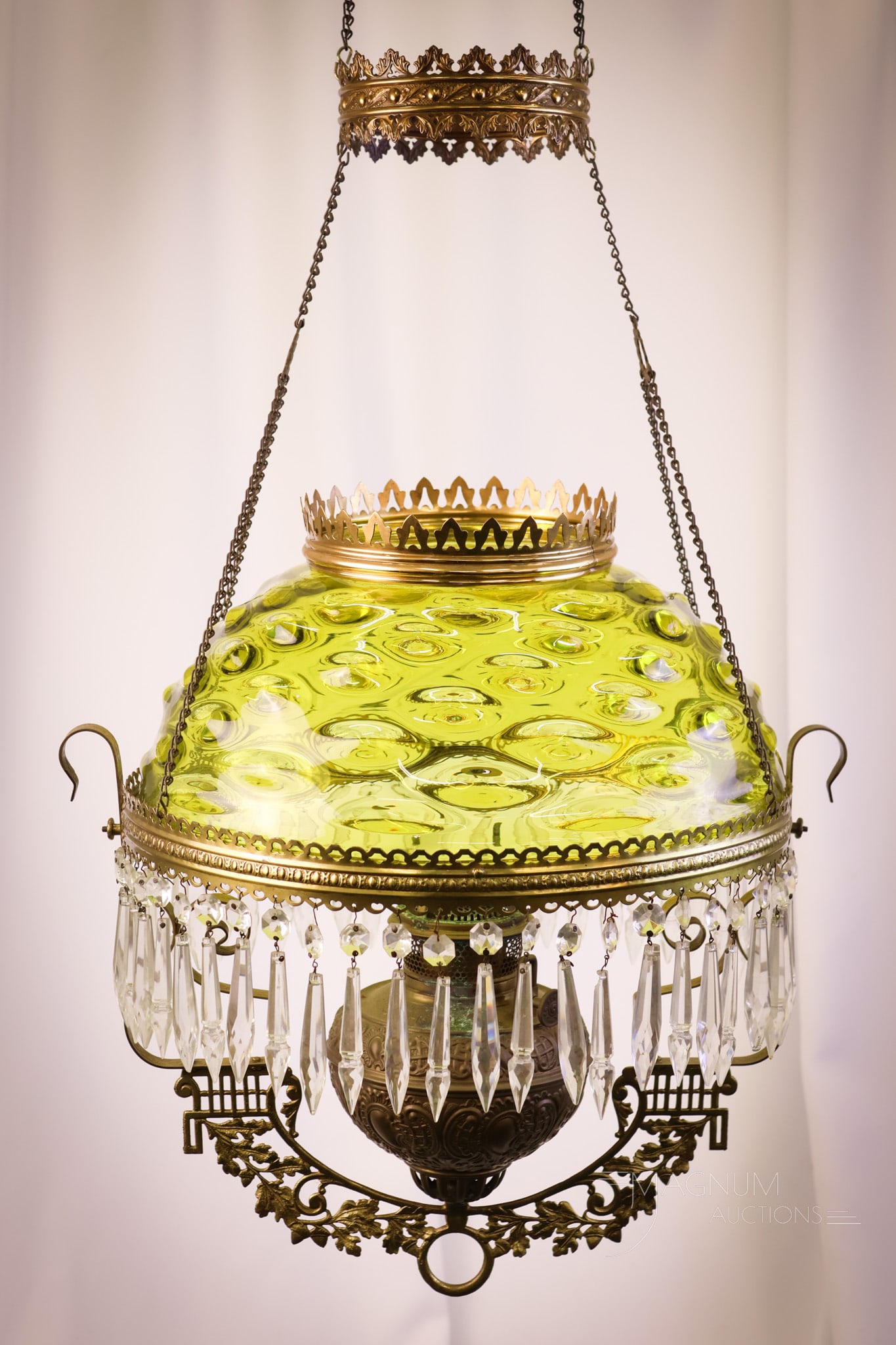 Green Bullseye Victorian Glass Hanging Parlor Oil Lamp: A fine green Bullseye pattern hanging parlor oil lamp. The lamp retains the motor and remains oil. Clear prisms decorate the frame. The lamp measures 43" long and 17" wide. SHIPPING NOTICE: If you cho