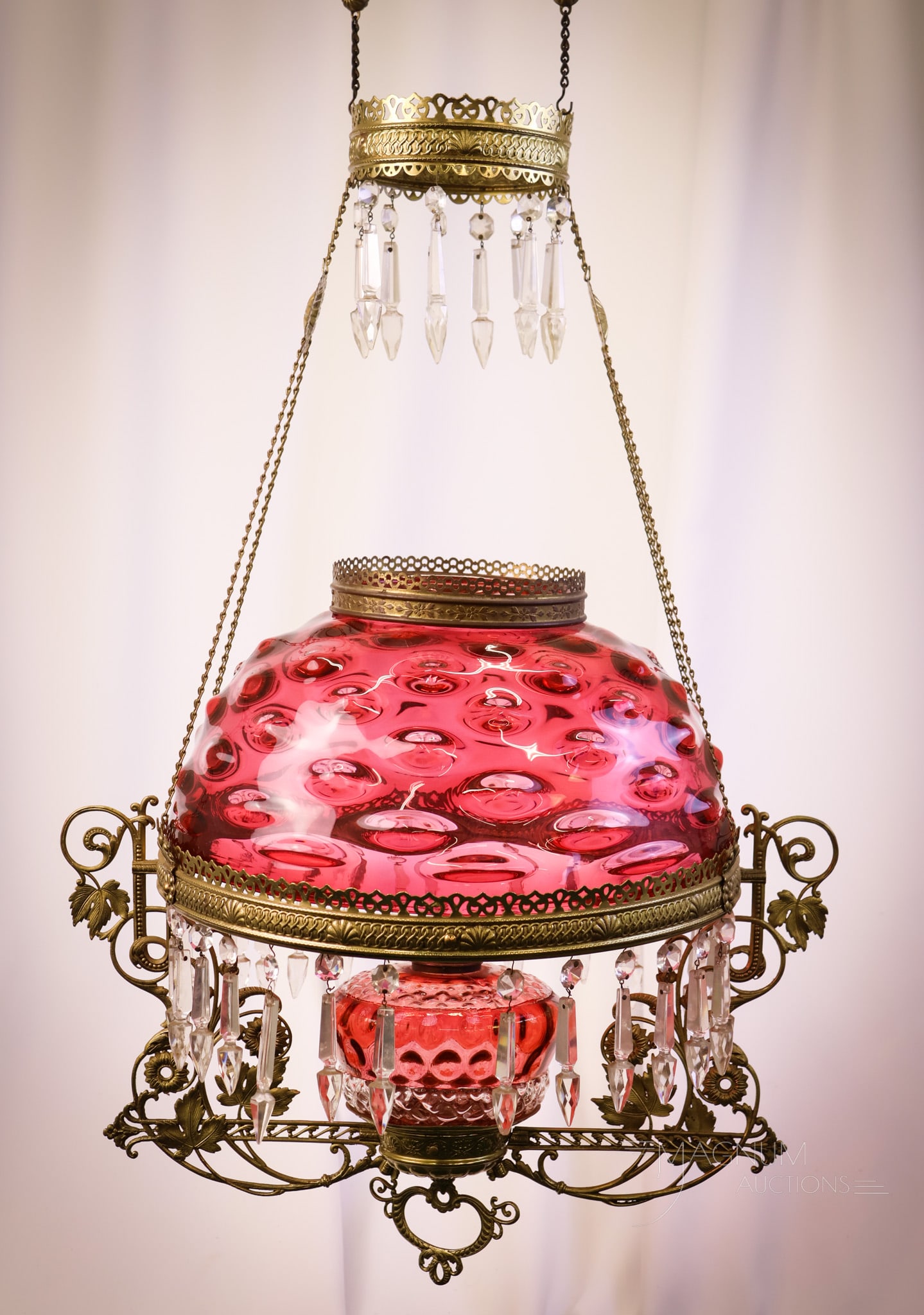 Ruby Bullseye Victorian Glass Hanging Parlor Oil Lamp: Another beautiful Victorian hanging parlor oil lamp. This example has a Ruby Bullseye pattern shade. The font is a clear diamond-quilt with a ruby Inverted Thumprint pattern. The brass frame is adorne