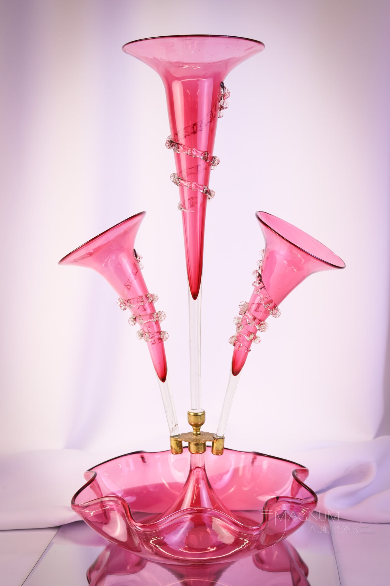 Cranberry Victorian Art Glass Three-Horn Epergne Centerpiece: A l,ovely piece of Victorian era art glass. This is an epergne with three horns in highly collectible cranberry glass. The piece has applied clear rigaree. The epergne measures 20" tall and 11 1/2" wi