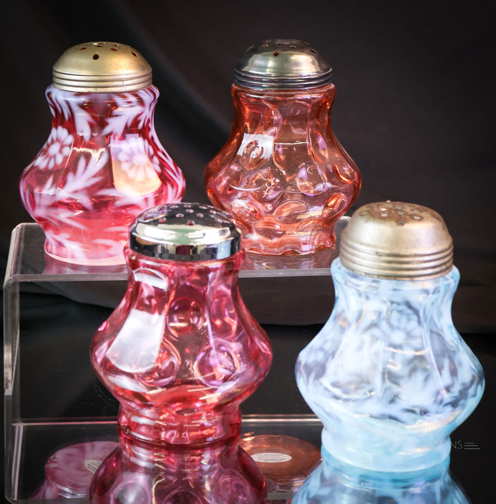 4 pc Lot Northwood Fenton 9-Panel Glass Sugar Shakers: Four distinct sugar shakers make up this desirable lot. There are three Fenton examples, including a blue and cranberry Daisy & Fern pattern and a cranberry Thumbprint. The fourth is a Northwood bitte
