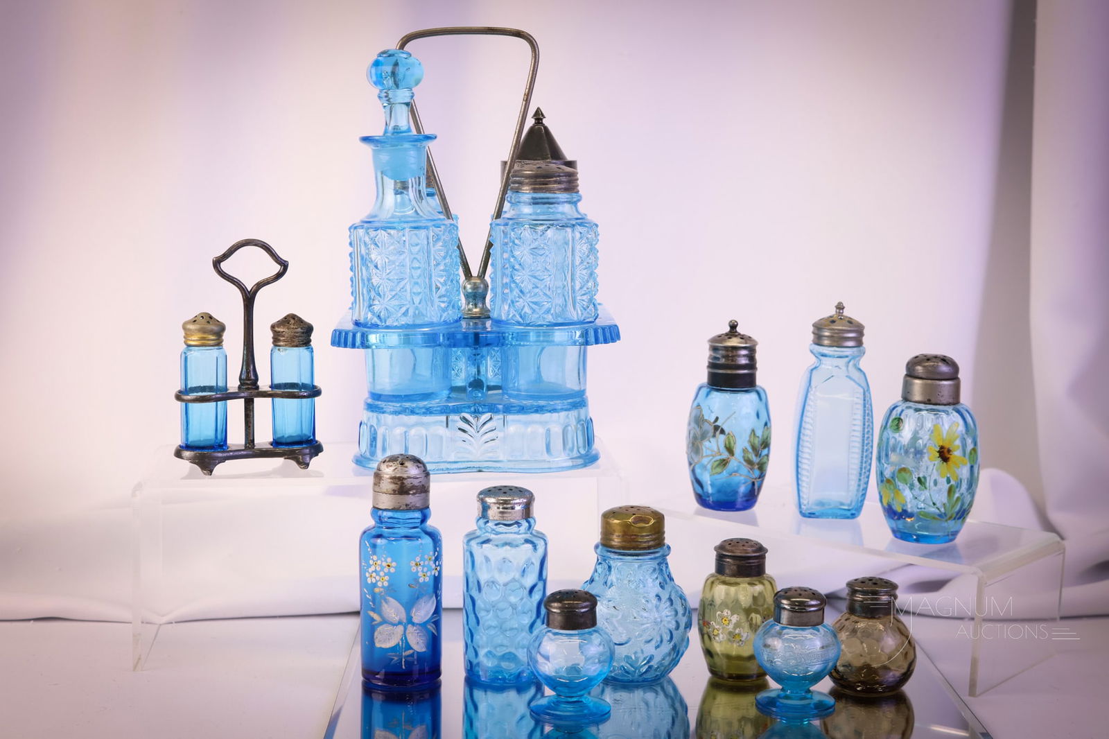 13 pc Lot Blue & Amber Victorian Glass Salt Shakers: Victorian lot of thirteen glass salt shakers in various colors of blue and amber. The tallest measures 9" tall and 6" wide. Chips are noted to the edges of the glass shaker holder. SHIPPING NOTICE: If