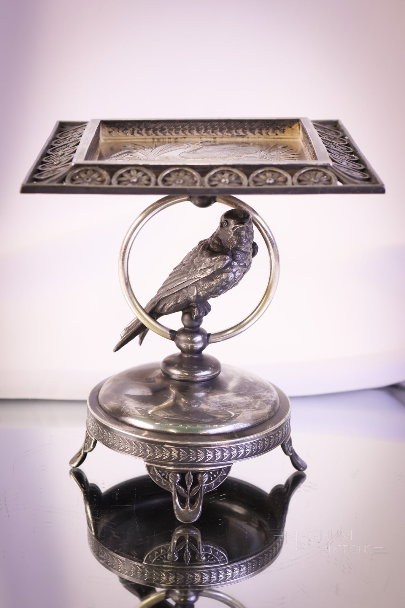 Victorian Pairpoint Figural Parakeet Silverplate Calling Card Tray: A nice find for your Victoriana collection. This is a calling card tray with a figural parakeet on the ring stem. The top surface has an embossed design. This piece is signed Pairpoint. The piece meas