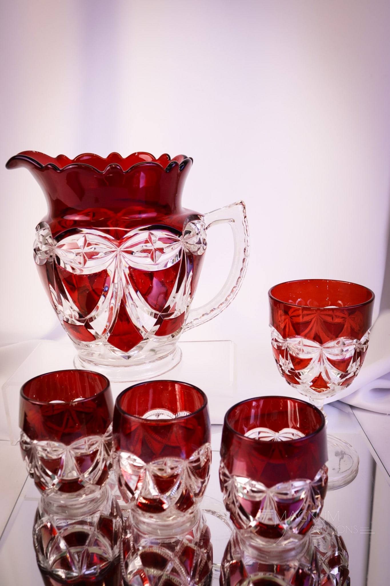 5 pc Lot Riverside Ruby Stained Victoria Victorian Glass: Five rich ruby-stained finds in Riverside Victorian glass that are sure to please. This lot offers a water pitcher, three tumblers, and a goblet. The tallest measures 8". Provenance: This item is fro