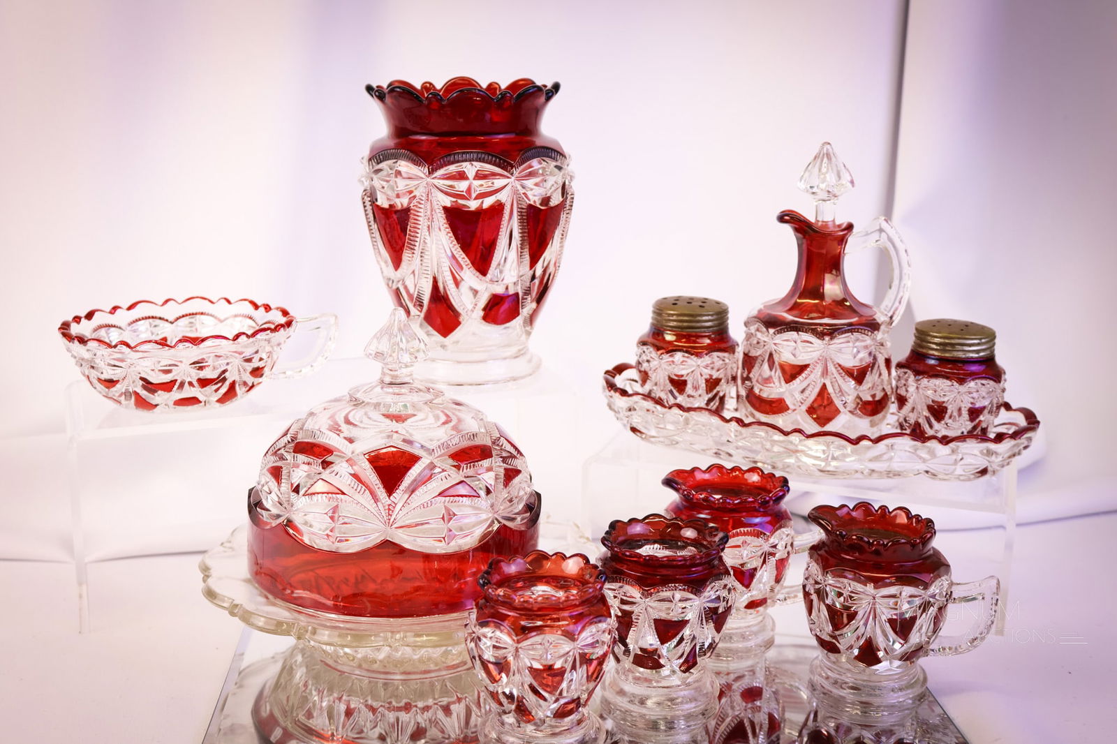 11 pc Lot Ruby Stained Victorian Glass Victoria Pattern: Eleven collectible pieces of Riverside Victoria Victorian pattern glass that will delight. This lot offers two toothpick holders, two mini-creamers, a nappy, a butter dish, a celery vase, and a cruet