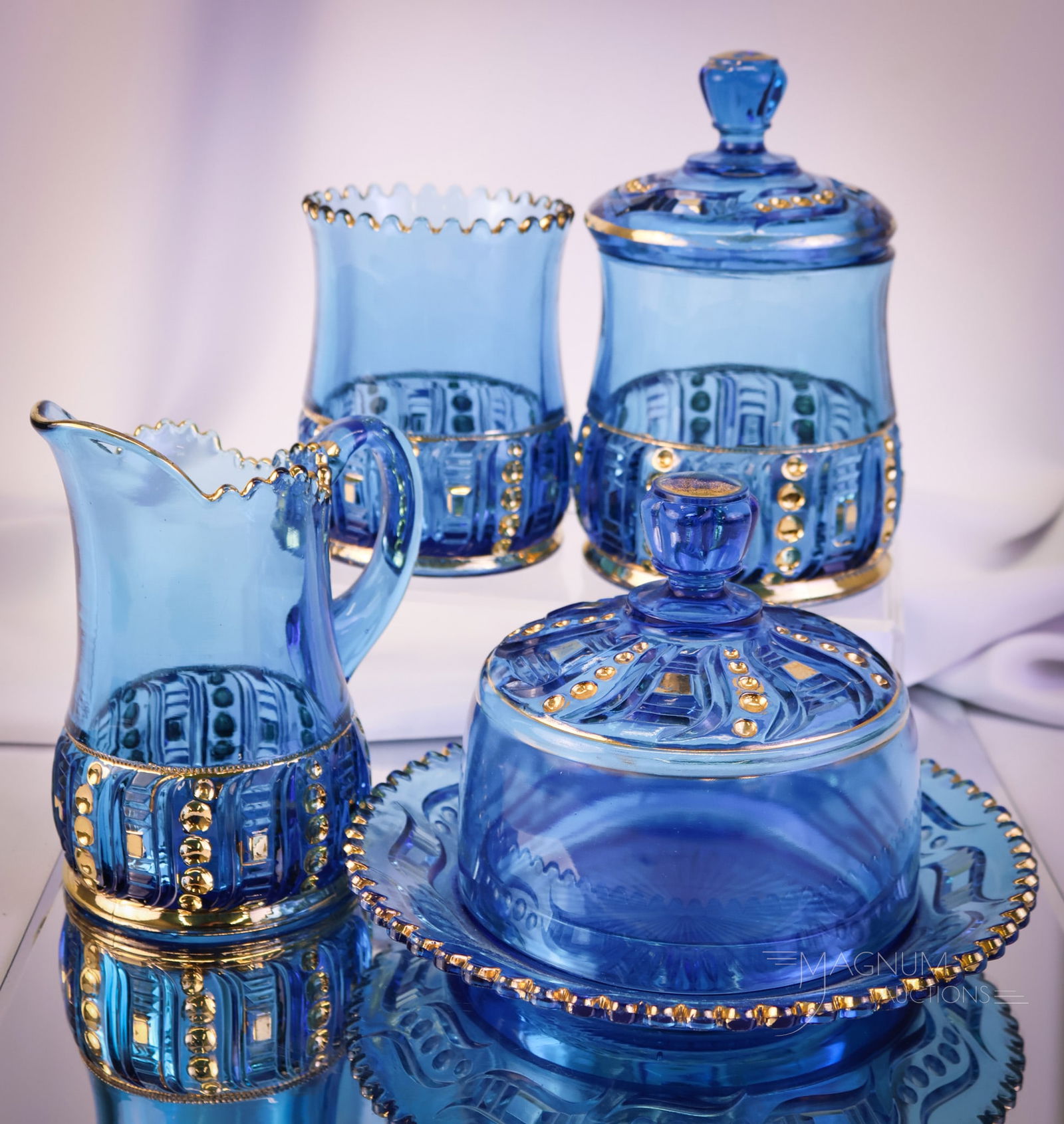 4 pc Lot Riverside Victorian Glass Seedpod Blue & Gold Table Set: A wonderful, complete four-piece table set in the Riverside pattern Seedpod. This set is in blue with gilt decoration. The tallest of the offerings measures 7". A chip/flake is noted on the sugar lid