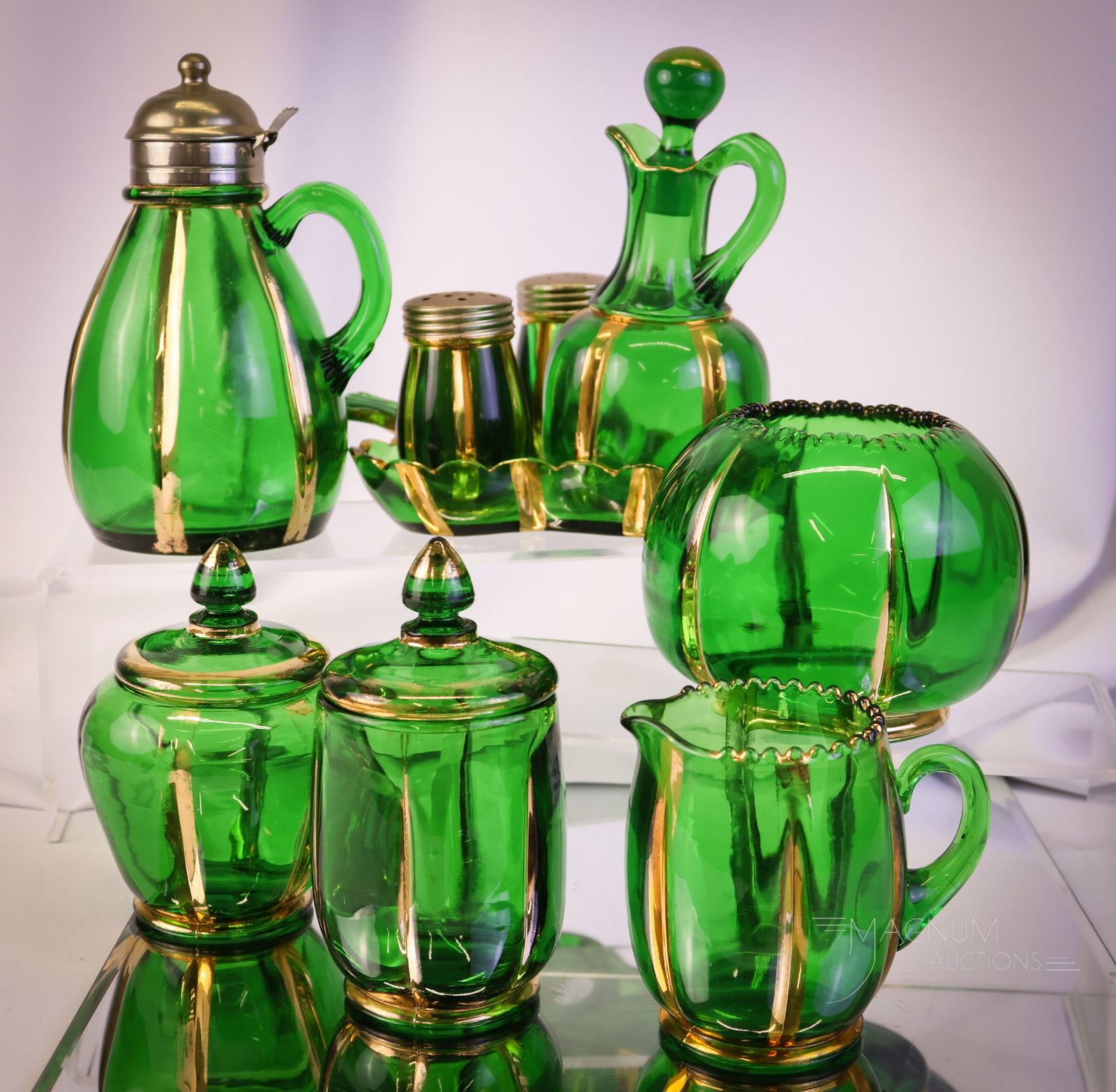 9 pc Lot Riverside X-Ray Green & Gold Victorian Glass: A plentiful lot of Riverside Victorian glass. This lot consists of pieces in green with gold decoration. The offerings include a syrup, a cruet condiment set consisting of a cruet, shakers, and a tray