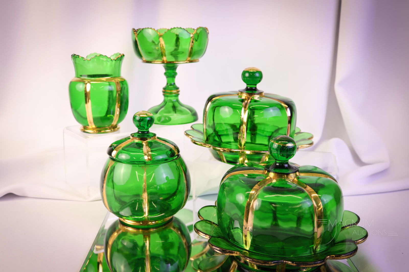 5 pc Lot Riverside X-Ray Green & Gold Victorian Glass: A five-piece offering of Riverside X-Ray pattern in green with gold decoration. This lot consists of two butter dishes, a covered sugar, a spooner, and lastly, a jelly compote. The tallest measures 6