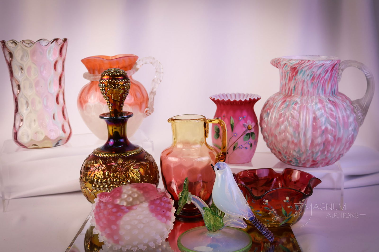 9 pc Lot Art Glass: Step right up and bid to win this generous offering of desirable and yet art glass. This lot includes an amberina, spatter, decorated mother-of-pearl, Murano, carnival, and so much more! The tallest o