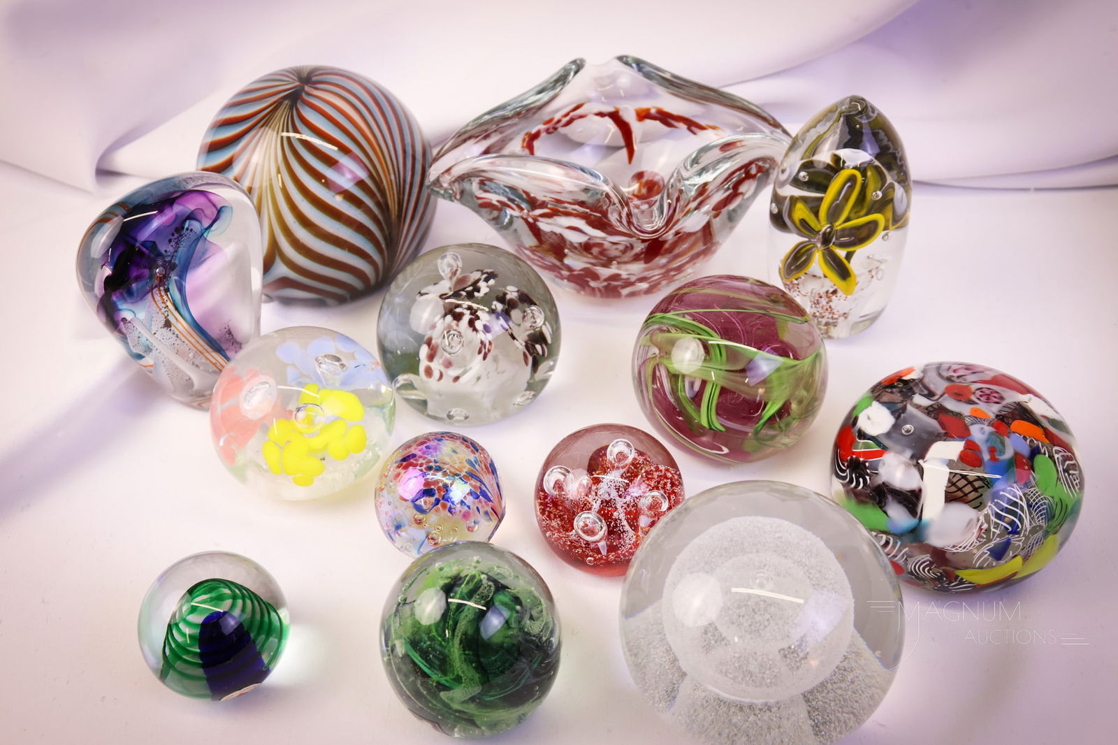 13 pc Lot Art Glass Paperweights: Thirteen fine examples of art glass paperweights. One is actually an ashtray. Examples made by Murano and others. The tallest measures 4 1/2". SHIPPING NOTICE: If you choose not to utilize the LiveAuc