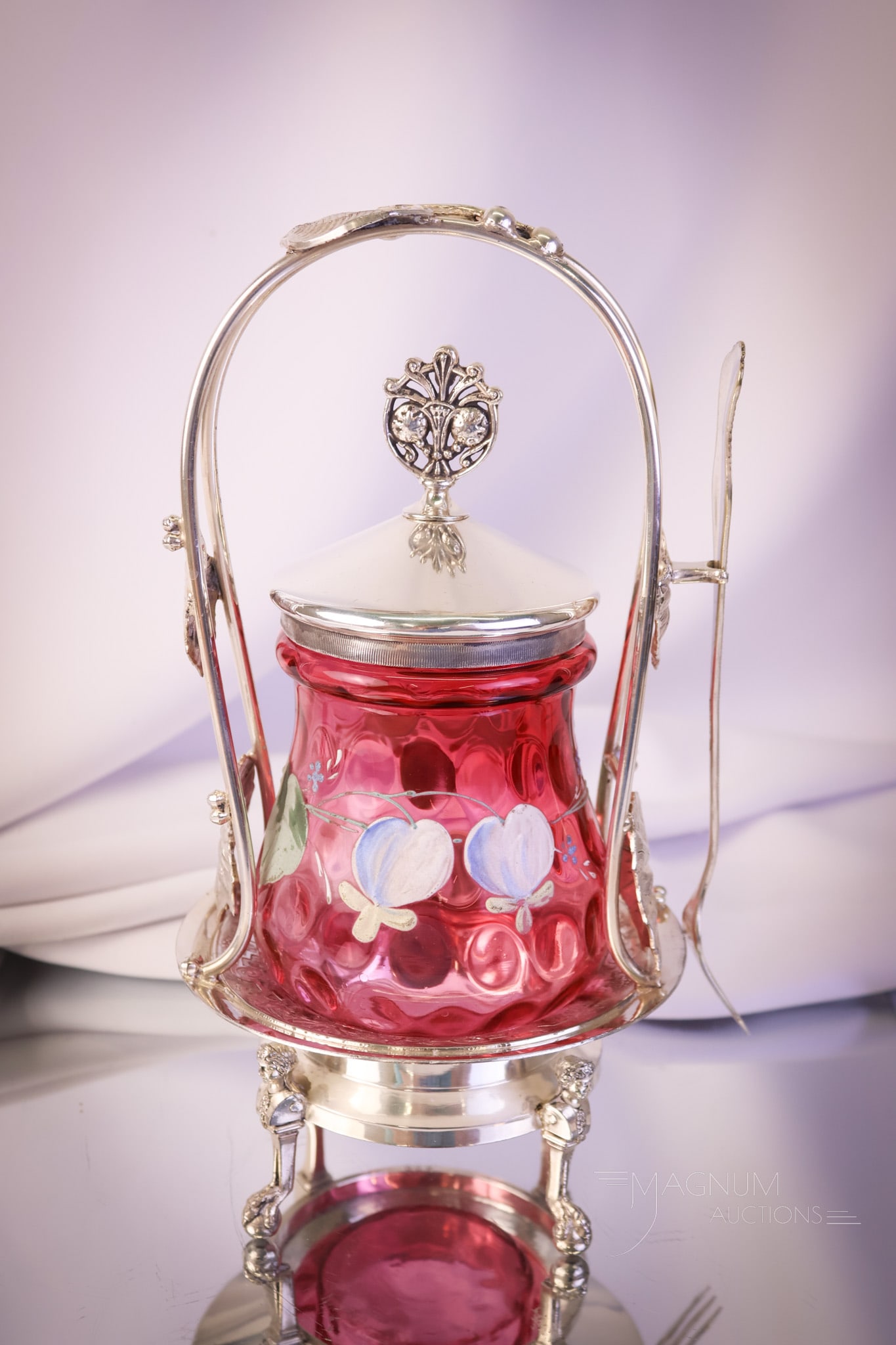 Reed & Barton Victorian Silverplate Cranberry Enameled Glass Pickle Castor: A fine example of Victorian silverplate and cranberry glass. This pickle castor measures 10 1/2" tall. The frame is signed Reed and Barton. The jar is cranberry enameled with bleeding heart flowers. A