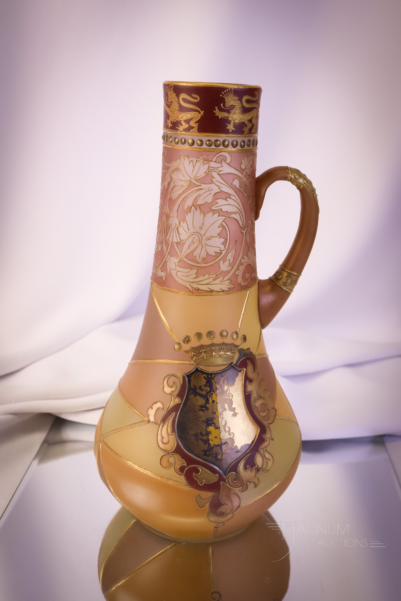 Mt. Washington Royal Flemish 12" Victorian Art Glass Pitcher: A phenomenal find in Mt. Washington Art Glass. This pitcher or ewer measures 12" tall. This beautiful piece of art glass is decorated with a Heraldry Shield and a Cross with rampant lions and lions ar