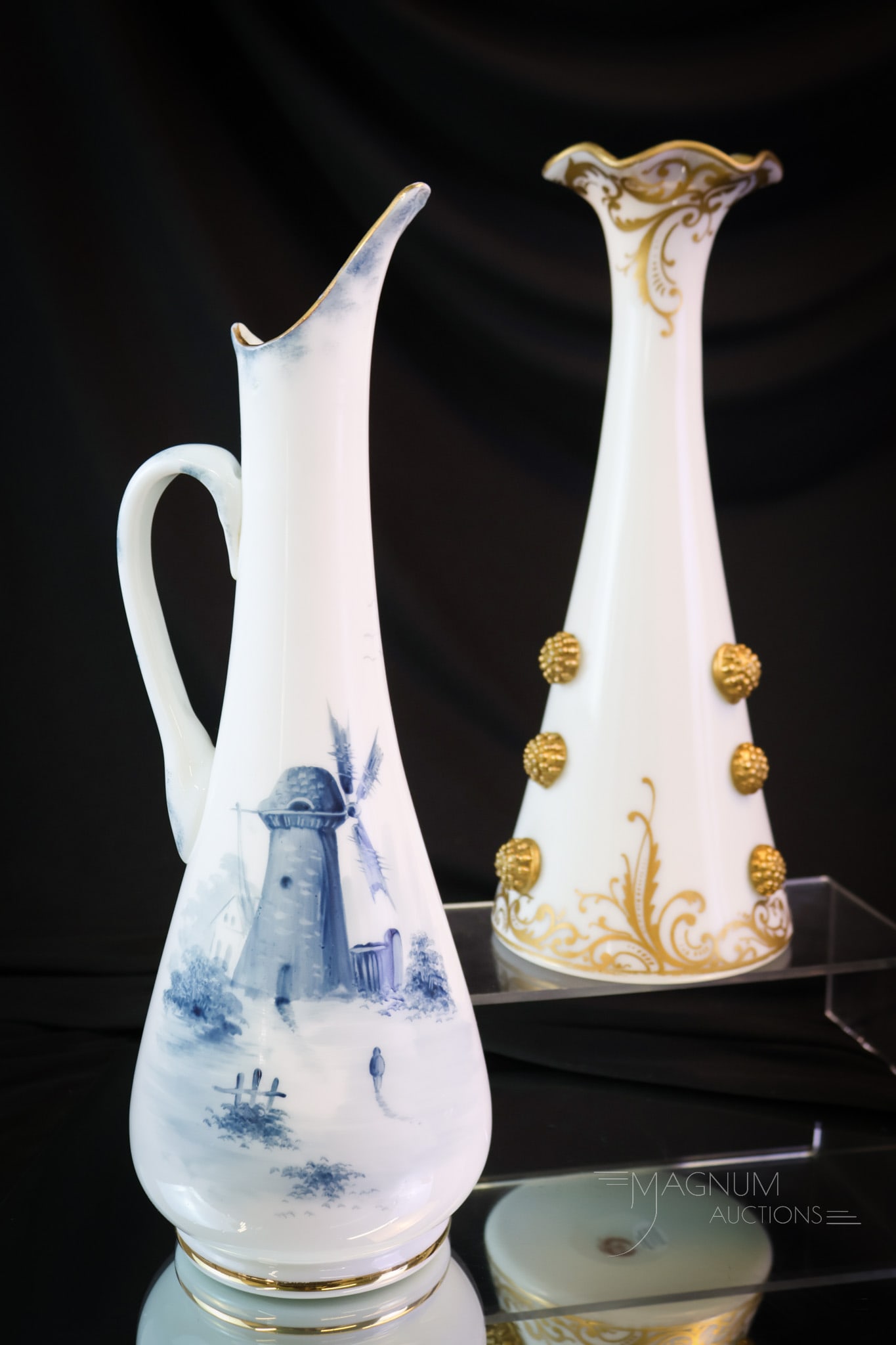 2 pc Lot Mt. Washington Victorian Colonial Ware Art Glass: Two fine examples of Mt. Washington art glass in their Colonial Ware line. The first is a large vase with applied gold prunts and decoration. The second is a blue Delft decorated ewer. The tallest mea