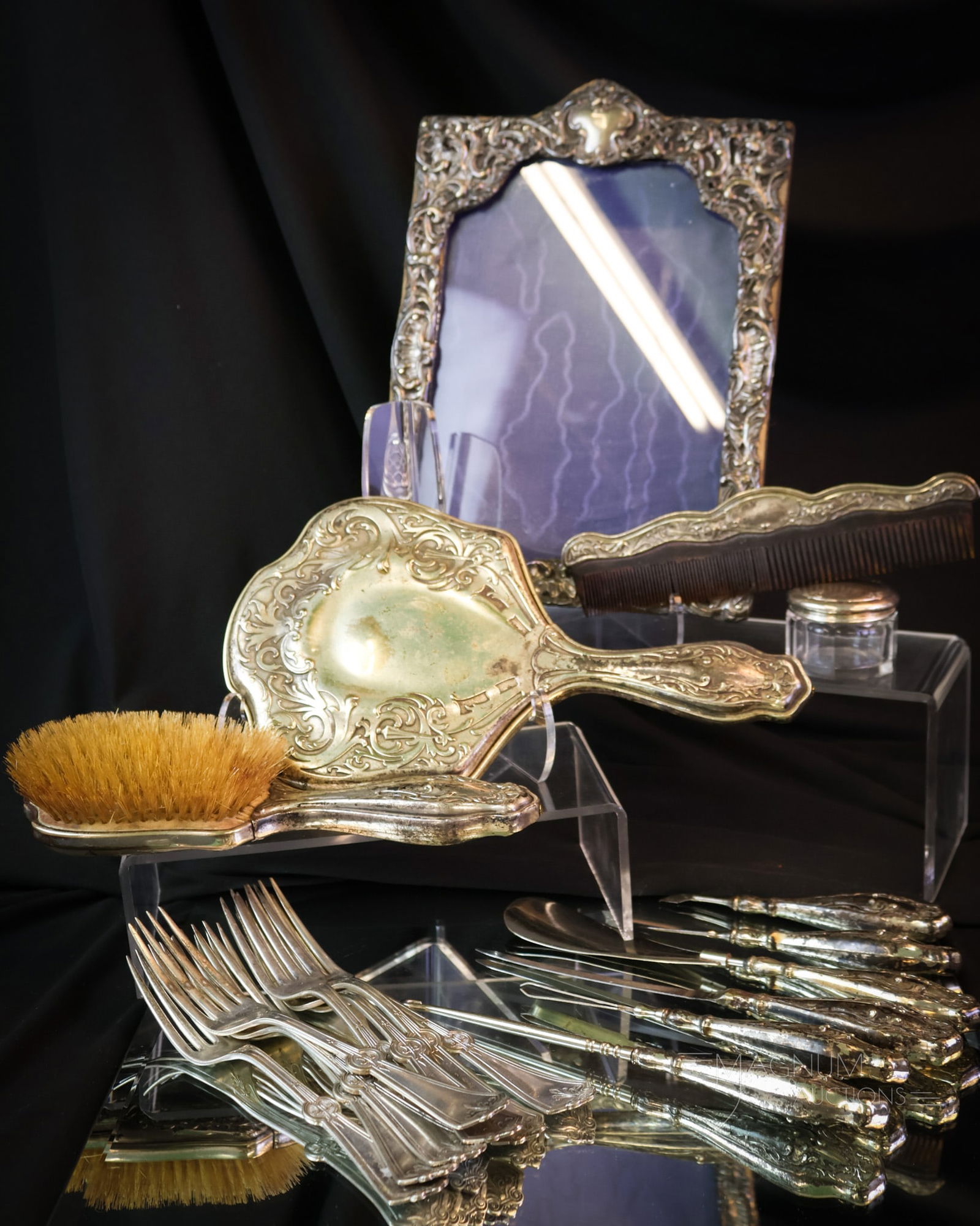 9 pc Lot Sterling & Silverplate: A select offering of nine pieces of sterling and silverplate. This lot includesvarious pieces marked G. silver in repousee vanity items that include a mirror, a brush,& various tools. There are 8 Roge