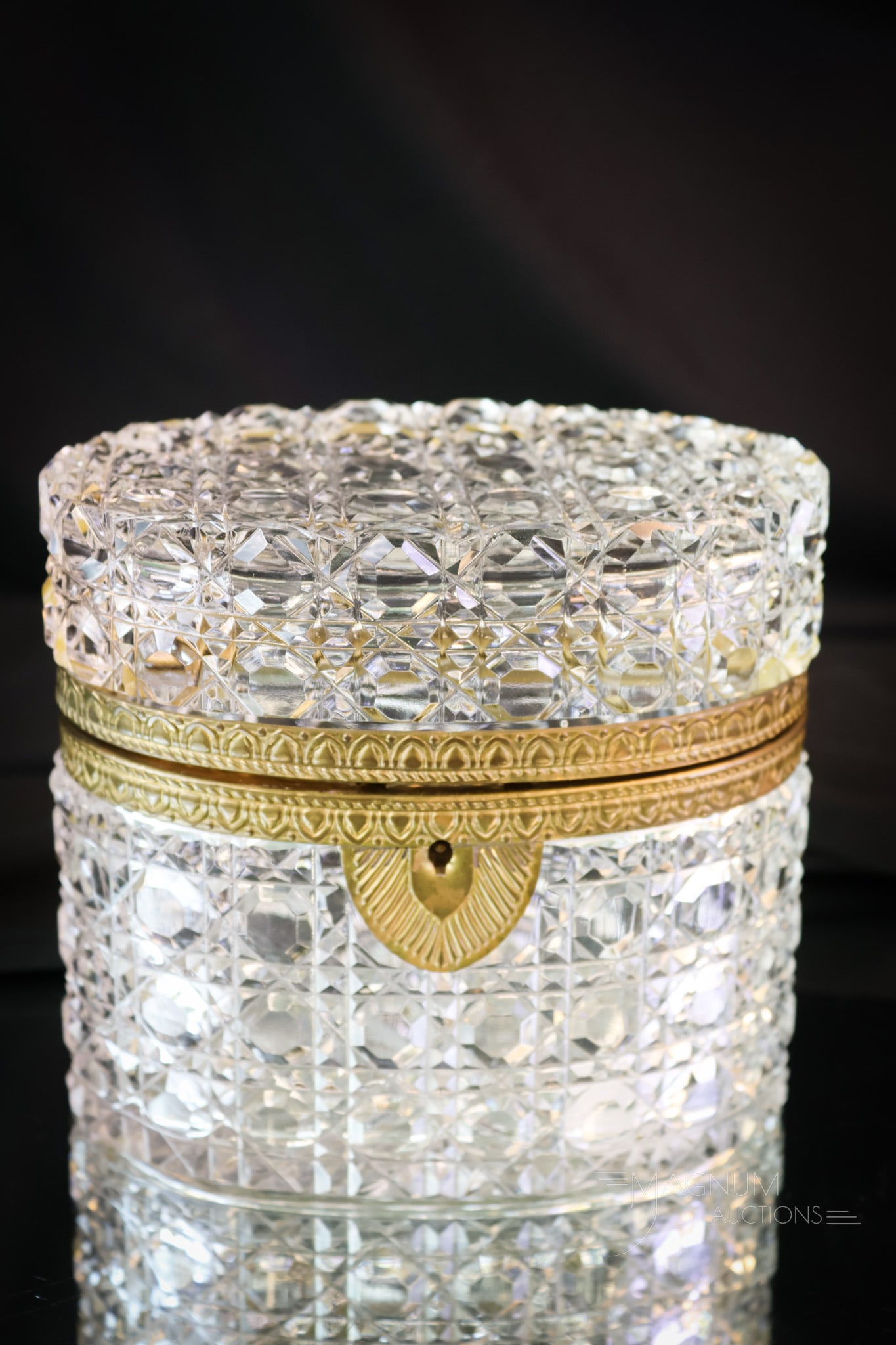 Oval Cut Crystal & Brass Jewelry Casket: Another gorgeous find in a cut crystal and brass jewelry casket. This one is cut in a button and crosshatch pattern. The casket retains the original key. The box measures 5" tall and 5 1/2". SHIPPING