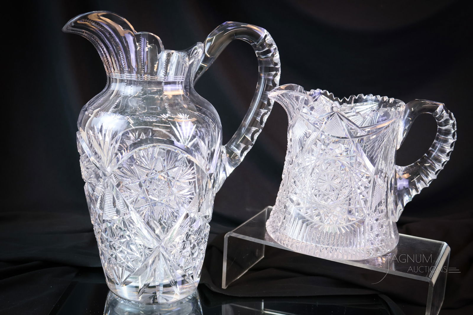2 pc Lot ABP American Brilliant Period Cut Glass: Two desirable finds in American Brilliant Period cut glass water pitchers. The first is a tall example with a hobstar and fan cutting with a notched handle. The second is a shorter version with hobsta