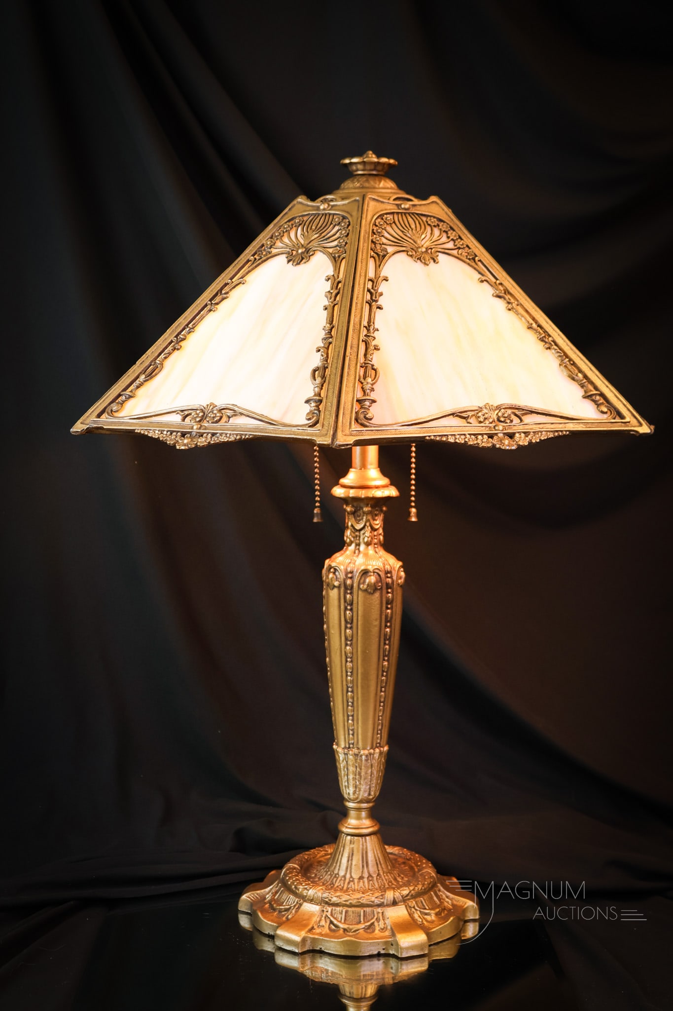 Pittsburgh Slag Glass Panel Lamp: A lovely offering of a Pittsburgh caramel slag panel lamp. This lamp features a gold-tone ornate design base. The lamp has Arrow sockets. The lamp measures 23" tall and 17 3/4" wide. The lamp has been