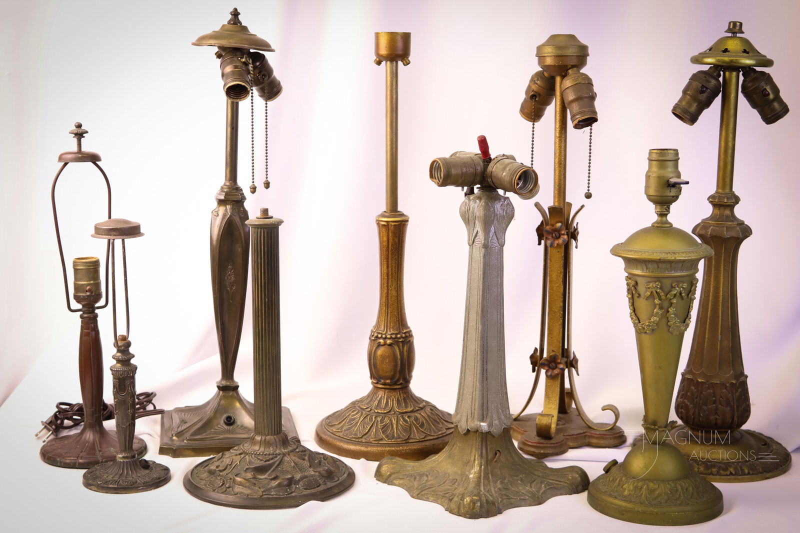 9 pc Lot Antique Table Lamp Bases Handel & More: A nice assortment of antique table lamp bases. The offering includes a marked Handel example. The bases are as found. The tallest measures 21 1/2". SHIPPING NOTICE: If you choose not to utilize the Li
