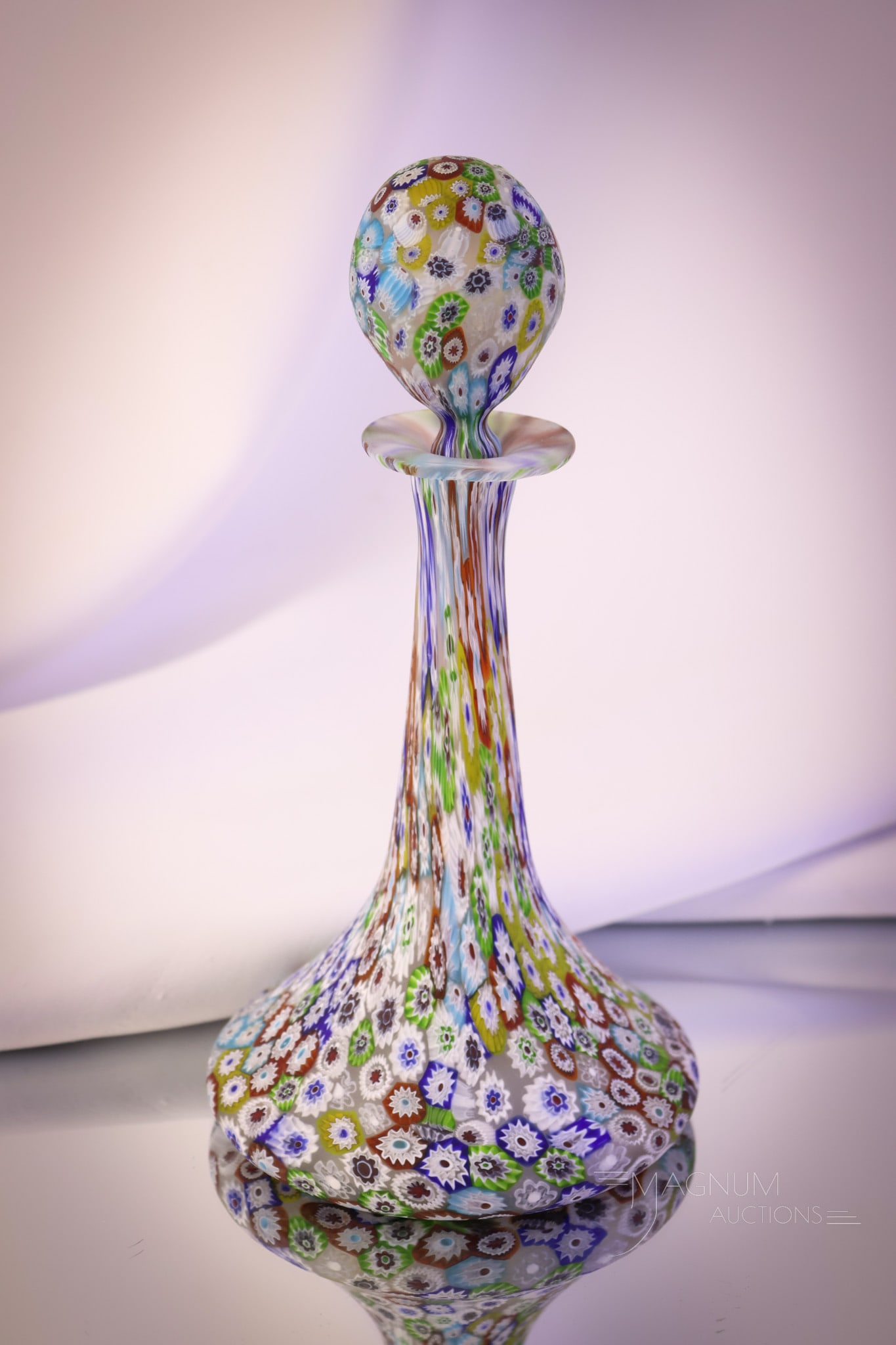 Italian Millefiori Fratelli Toso Art Glass Perfume Bottle: Ahighly collectible Fratelli Toso Italian art glass Millefiori perfume bottle. This tall example has a matching stopper. The perfume bottle measures 8" to the top. SHIPPING NOTICE: If you choose not t