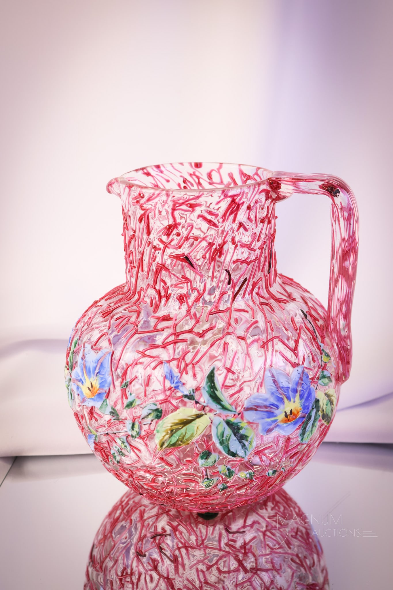 Victorian Peloton Bohemian Art Enameled Glass Water Pitcher: A super example of a Bohemian glass pink threaded Peloton water pitcher. This pitcher has enameled floral decoration. This pitcher measures 8" tall. SHIPPING NOTICE: If you choose not to utilize the L